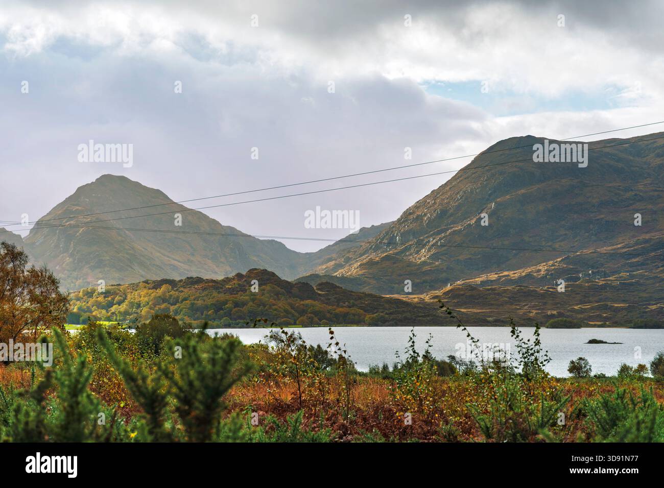Ampia vista sul Lough Guitane, ripide pendenze di Cappagh Glen, altopiani autunnali, cielo suggestivo, Co Kerry Foto Stock