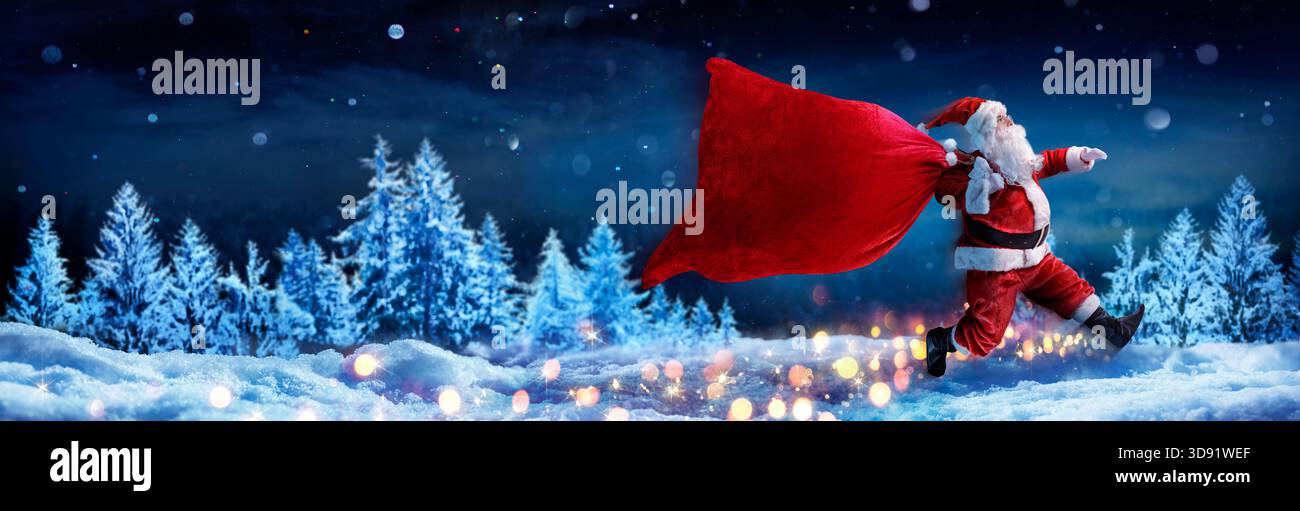 Babbo Natale con la borsa rossa che salta sulla neve nella foresta invernale innevata - consegna veloce presente Foto Stock