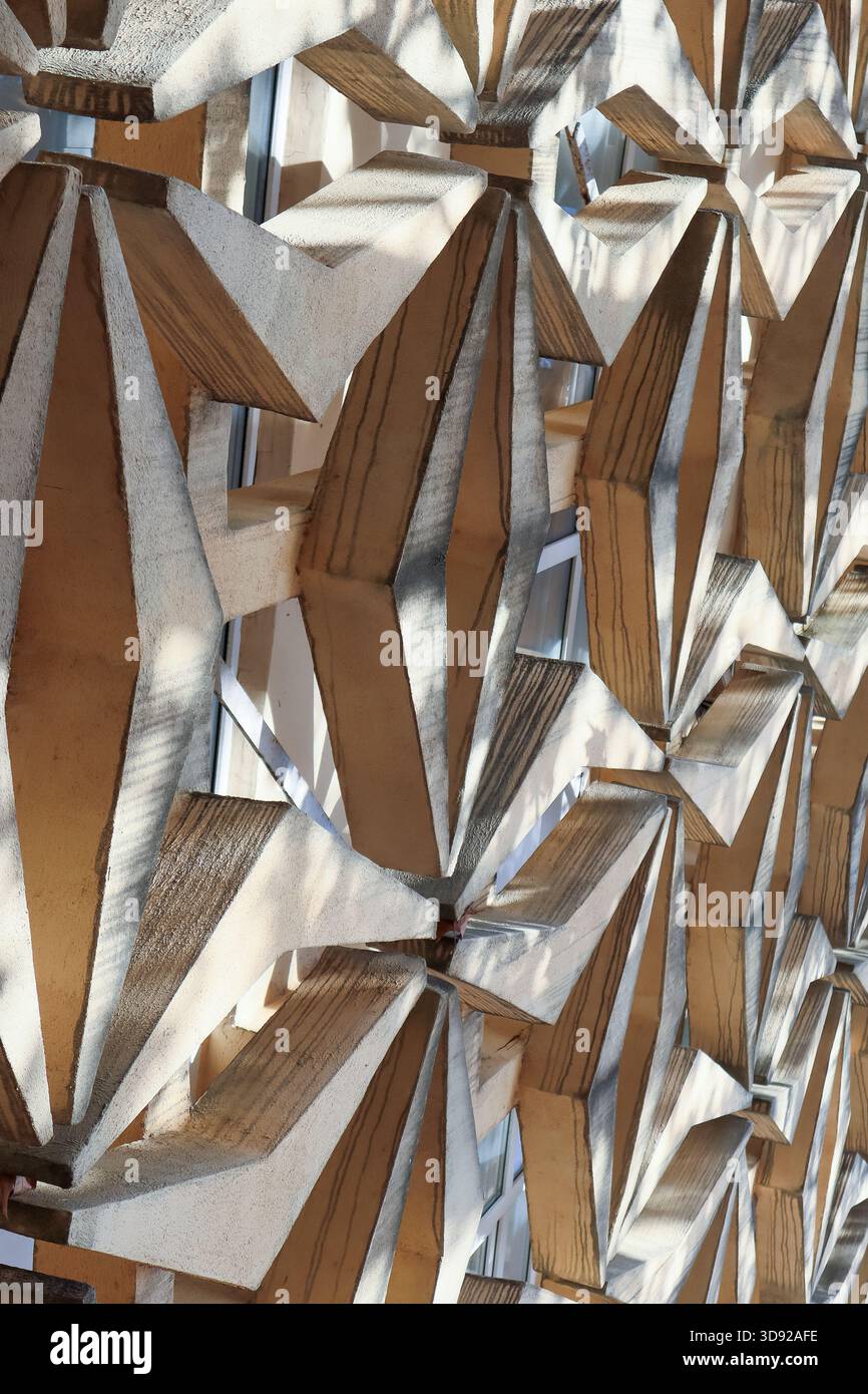 Primo piano della facciata architettonica con pannelli in legno bianco e marrone a forma di diamante che creano motivi d'ombra testurizzati. Foto Stock