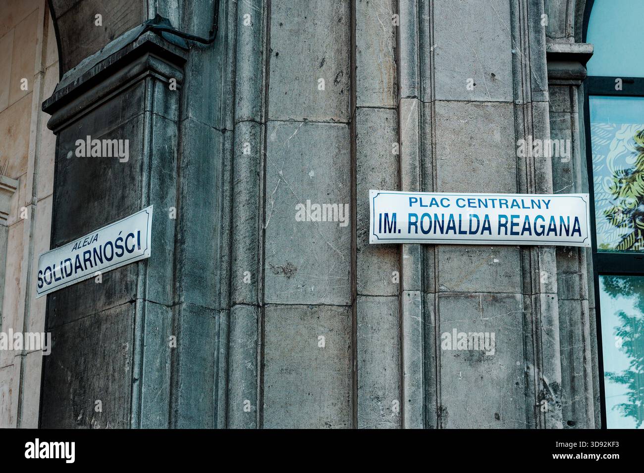 Indicazioni stradali per Aleja Solidarności e Piazza Ronald Reagan centrale sulla storica facciata in pietra di Nowa Huta. Foto Stock