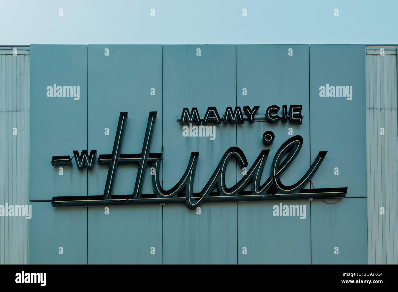 Insegna neon vintage “Mamy Cię W Hucie” sulla facciata dell'edificio a Nowa Huta. Foto Stock