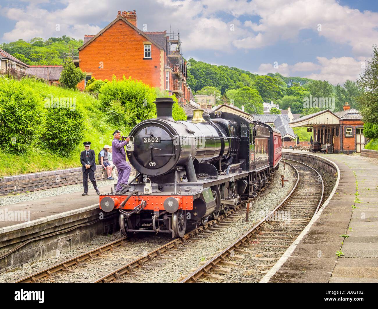 Membro dell’equipaggio che fissa le lampade alla locomotiva 3802 prima di lasciare la stazione di Llangollen. La locomotiva fu costruita nel 1938. Foto Stock