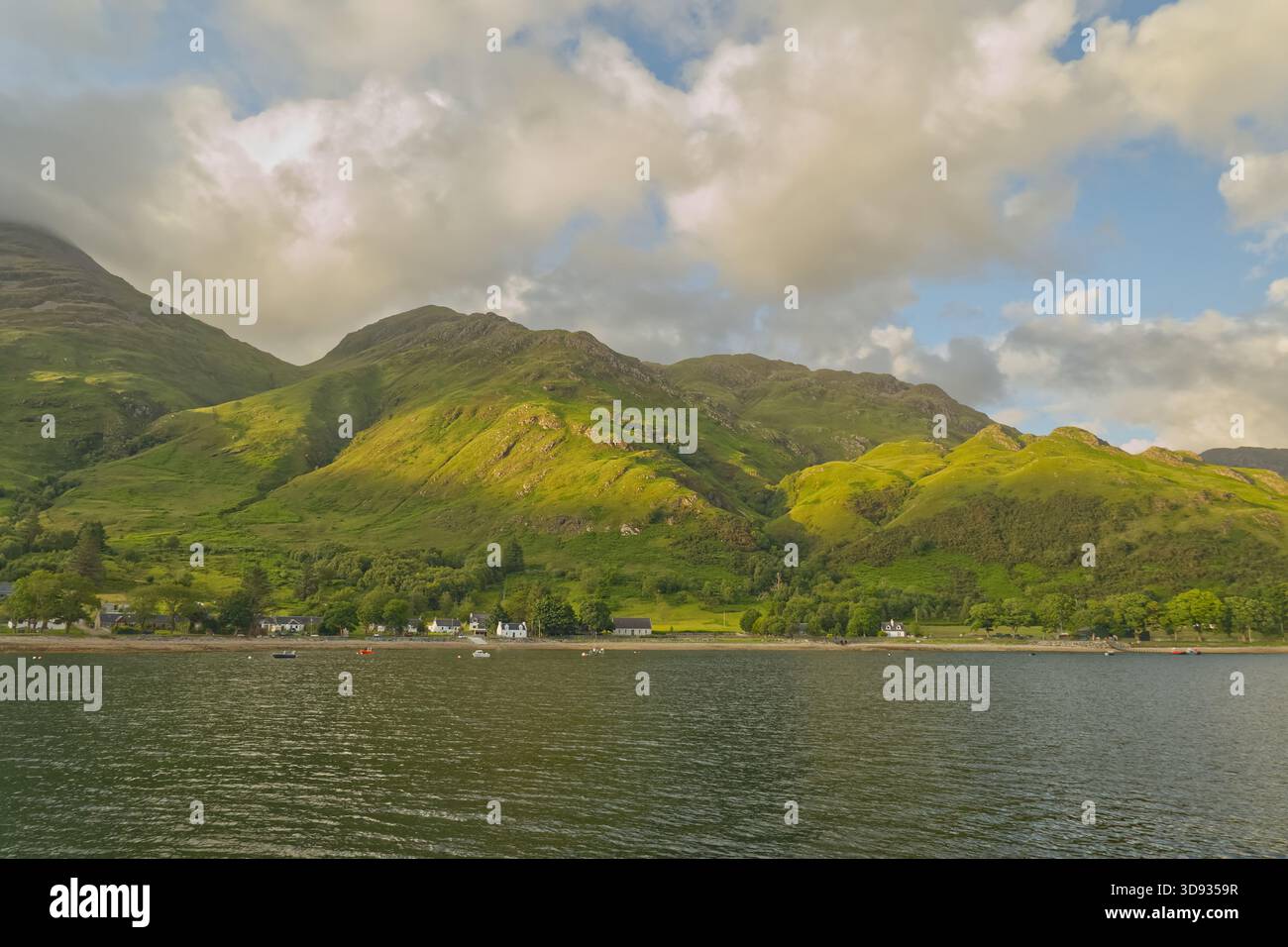Vista del remoto villaggio di Arnisdale sul Loch Hourn nelle Highlands scozzesi, visto dall'acqua sotto un cielo blu parzialmente nuvoloso. Foto Stock