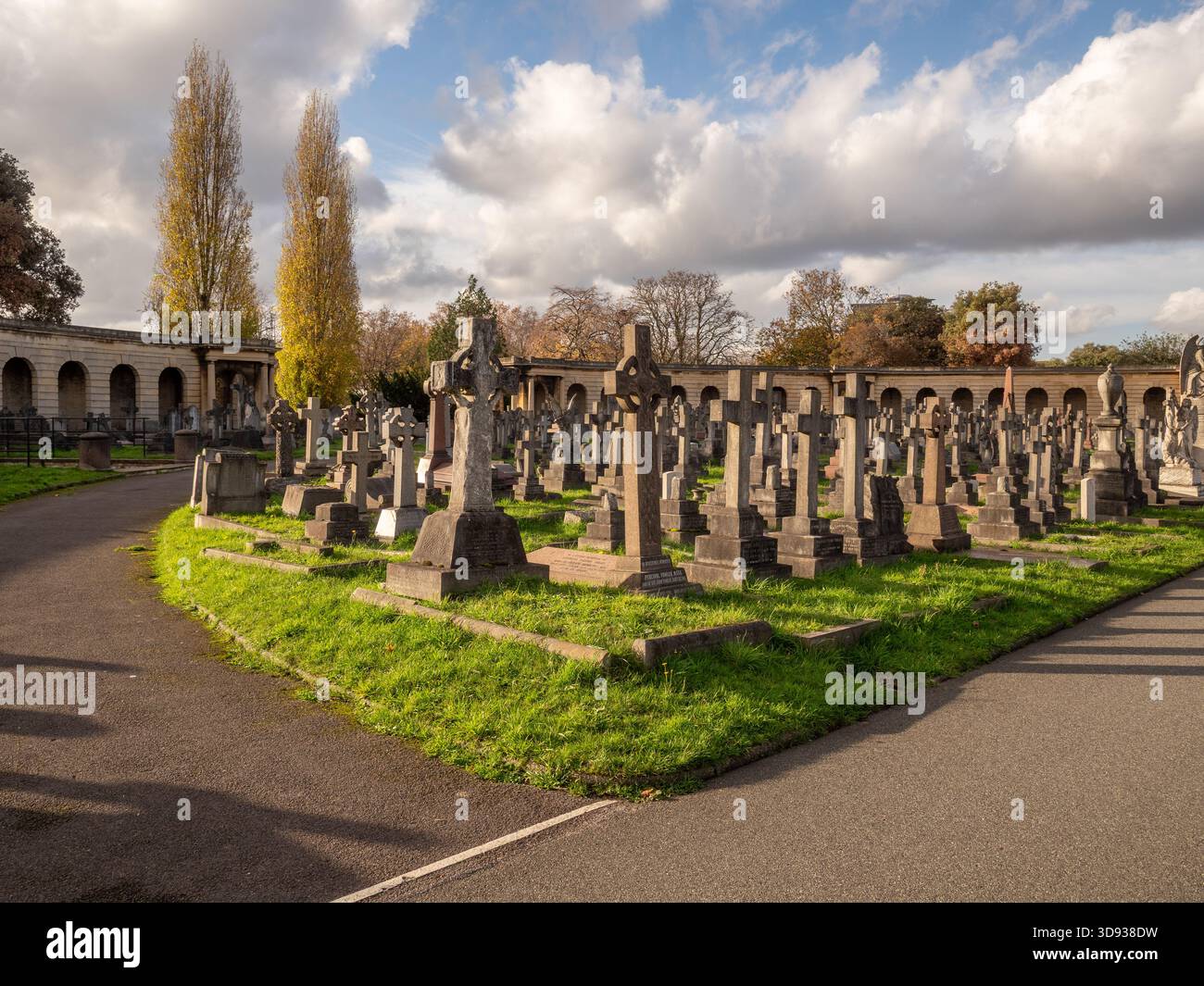 I colonnati del Great Circle del cimitero di Brompton, Londra, incorniciati da alti alberi autunnali ed erba. Foto Stock