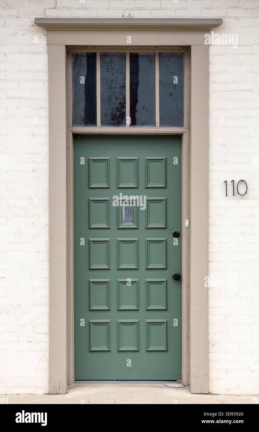 La portiera esterna a quindici pannelli è stata dipinta di verde salvia con maniglia e serratura nere Foto Stock