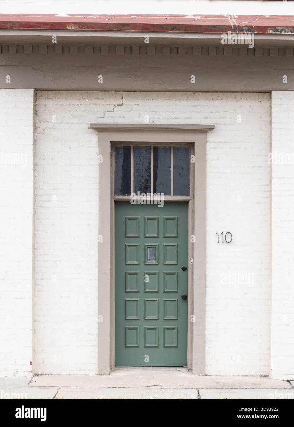 La portiera esterna a quindici pannelli è stata dipinta di verde salvia con maniglia e serratura nere Foto Stock
