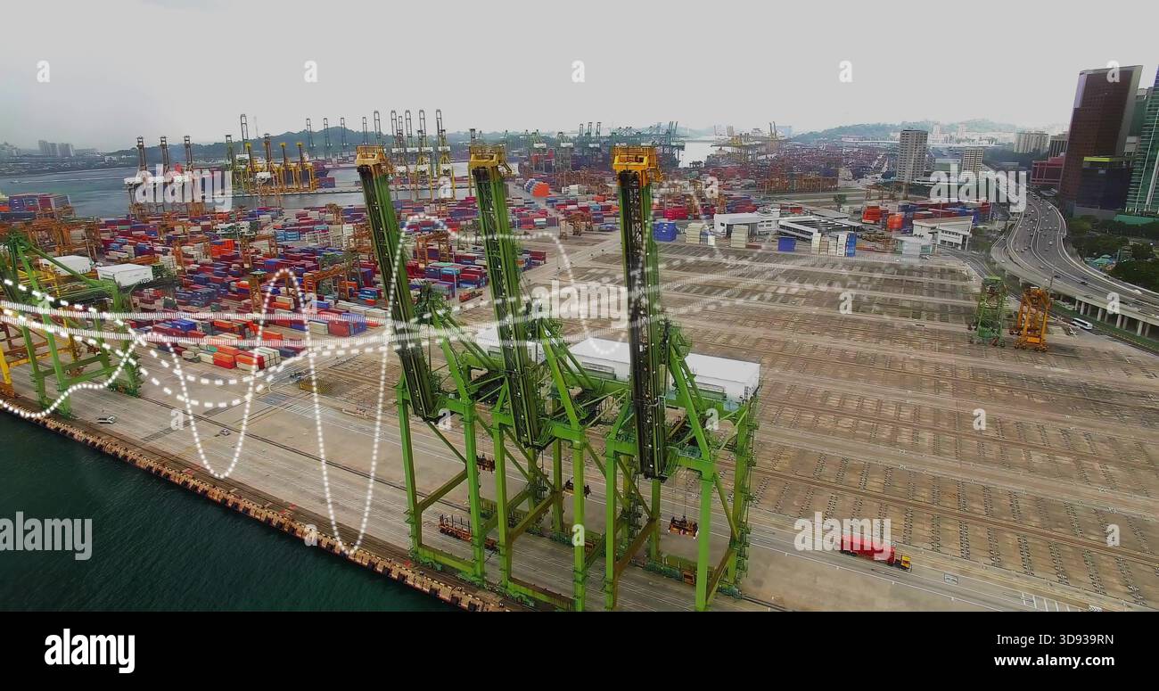 Visualizzazione di tre gru a cavalletto verdi su binari lungo la banchina, impilamento di contenitori vicino al carrello rosso Foto Stock