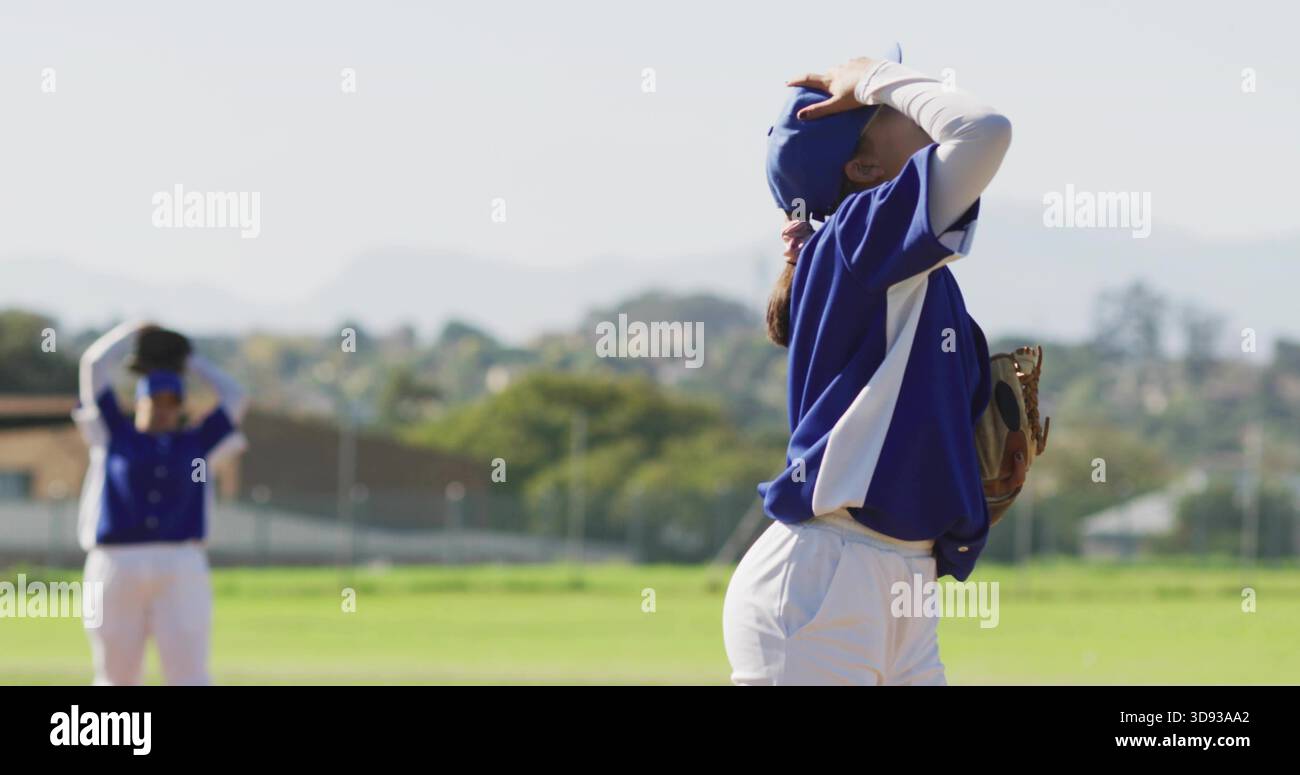 Con guanto in mano, giocatrice in maglia blu che mette le mani sulla testa in campo esterno, con tappi blu Foto Stock
