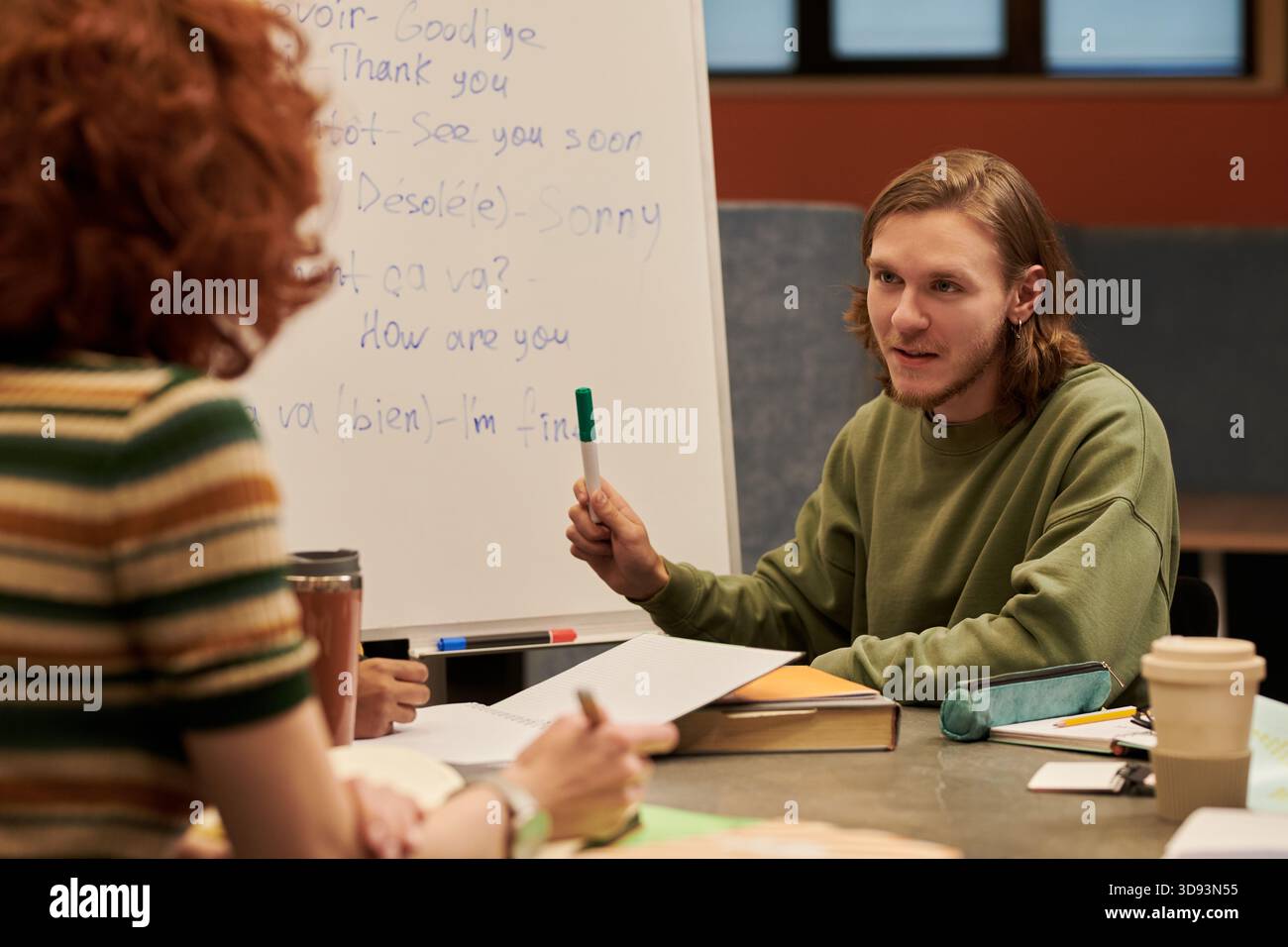 Young Man che spiega la lezione di lingua a Young Woman Foto Stock