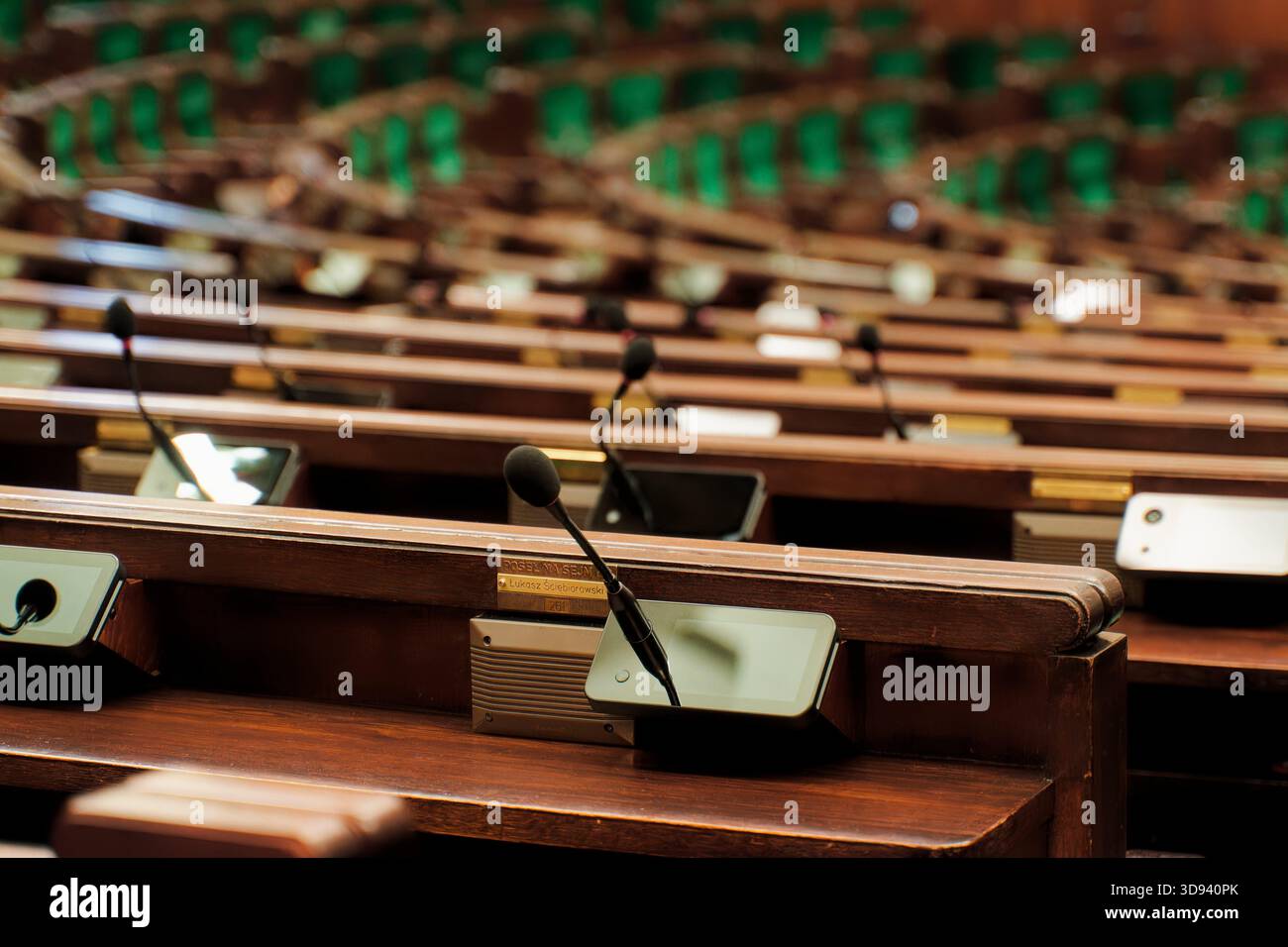 Scrivanie parlamentari vuote con microfoni nella camera Sejm. Foto Stock