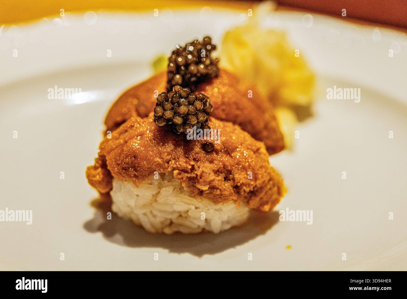 Sushi gourmet caratterizzato da sapori ricchi, condito con caviale e guarnito splendidamente, presentato su un piatto elegante, che mette in mostra l'arte culinaria. Foto Stock