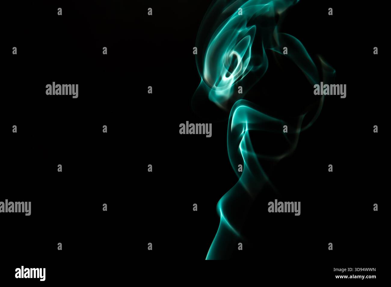 Motivo di fumo blu in Dark Studio che forma forme fluide astratte con accenti di luce soffusa Foto Stock