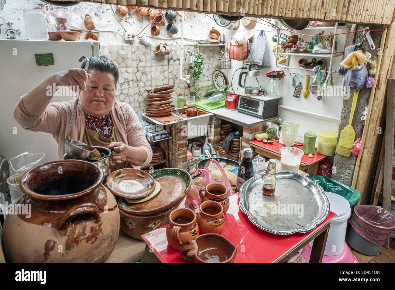 Città del Messico, Messico, Xochimilco, Dalia Restaurant Cafe, donna ispanica latinoamericana per adulti che serve bevande tradizionali in cucina, tazze di argilla, bevande fatte in casa, ingr Foto Stock
