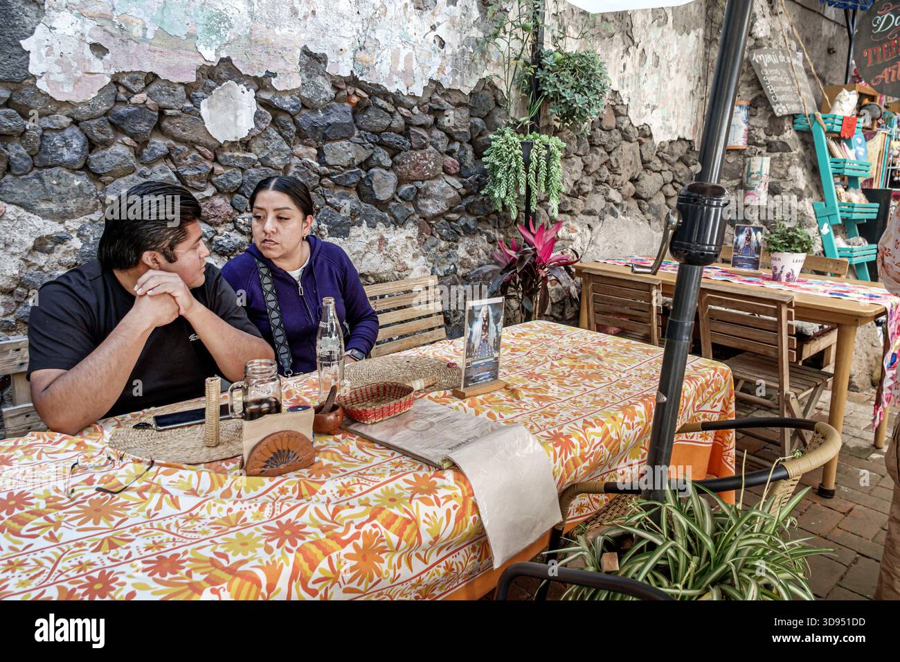 Città del Messico, Messico, Xochimilco, Dalia Restaurant Cafe, ispanico Latino coppia uomo donna adulti che parlano seduti al tavolo, bottiglia di vetro per bevande, parete in pietra rus Foto Stock