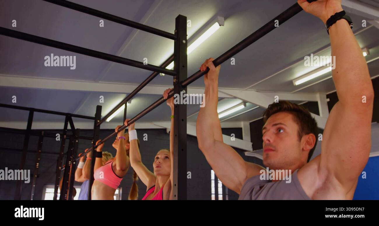 Tira fuori l'uomo sulla barra di presa destra nella palestra, indossa abiti da ginnastica, spazio fotocopie Foto Stock
