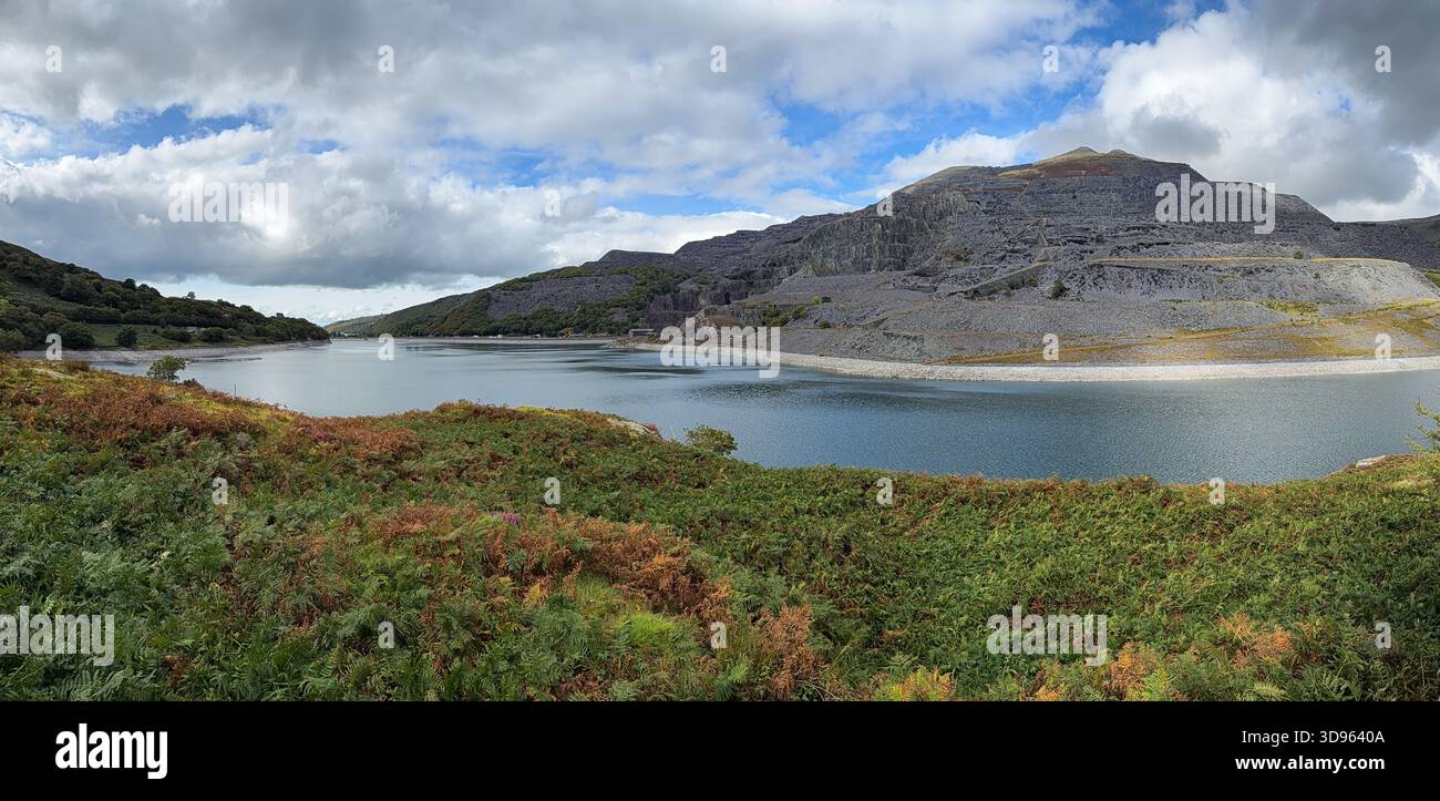 Panorama di nuvole rotte che gettano ombre su Llyn Peris e la cava di ardesia Foto Stock