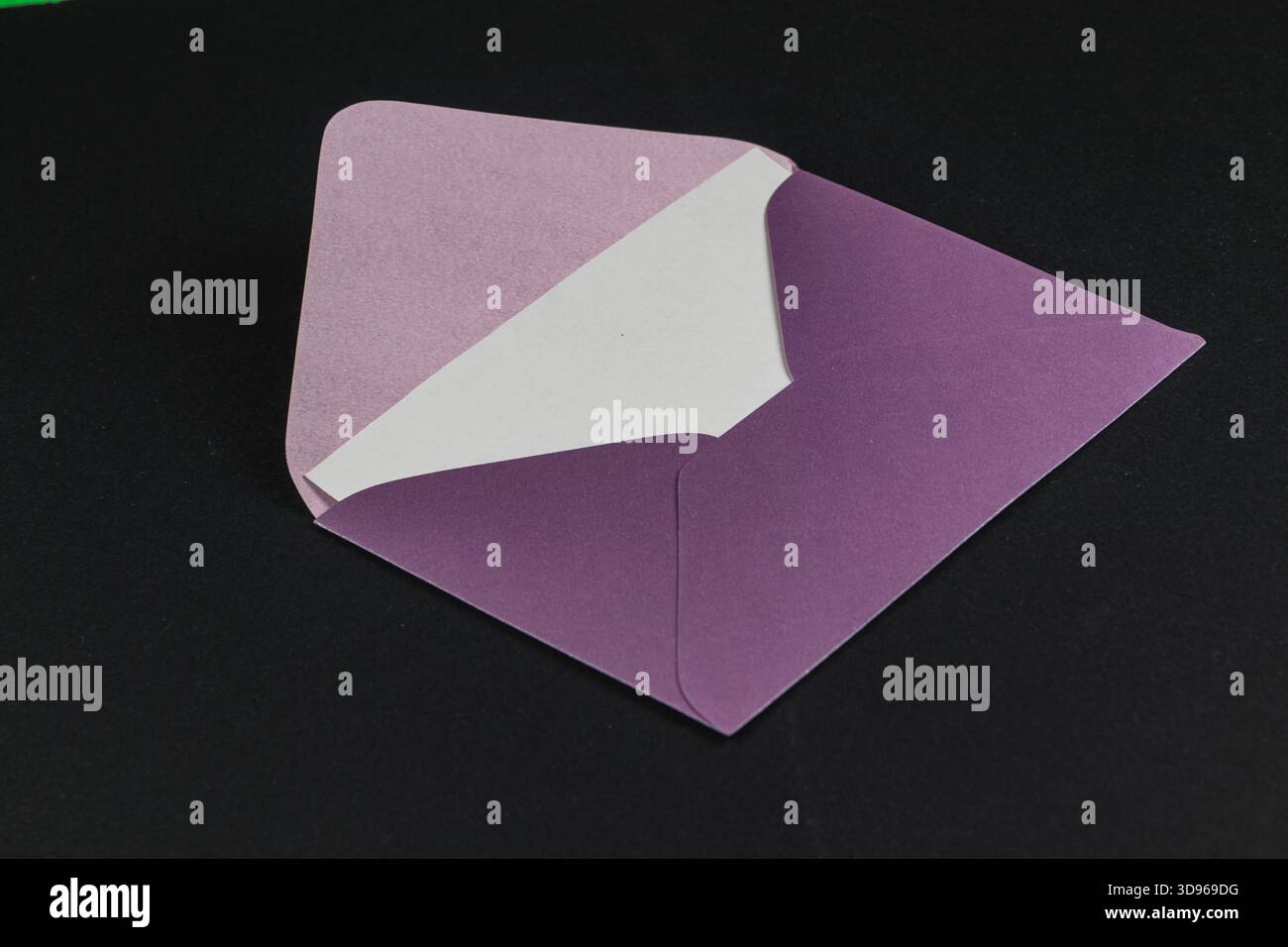Una busta ben confezionata presenta una fodera interna viola su un elegante sfondo nero. Il design mette in risalto una combinazione di colori e semplicità. Foto Stock