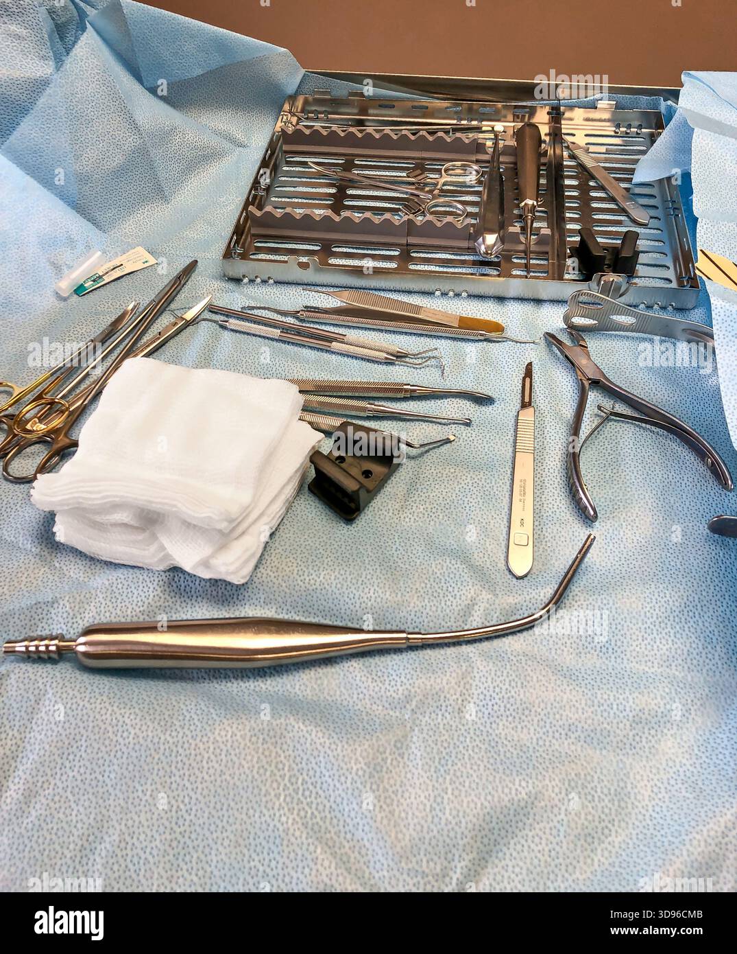 DULUTH, MN - 9 Mar 2020: Gli strumenti chirurgici sterili su un vassoio chirurgico monouso aperto di colore blu sono pronti per l'uso da parte di un chirurgo orale. Foto Stock