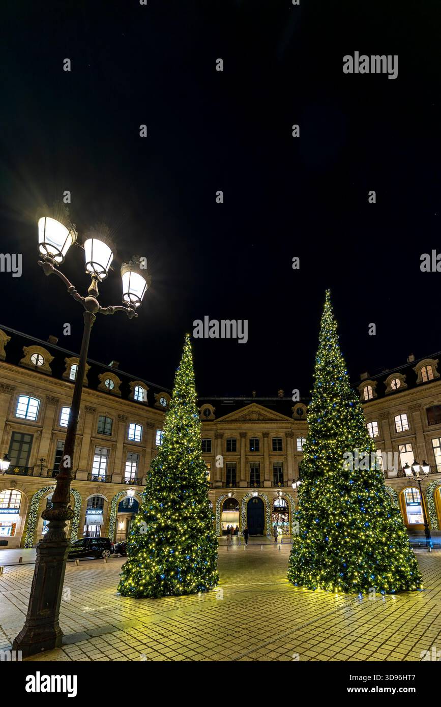 Parigi, Francia - 20 novembre 2025: Alberi di Natale decorati con splendide tinte, Place Vendome (piazza), Parigi, Francia. Enormi pini. Molto lussuoso Foto Stock