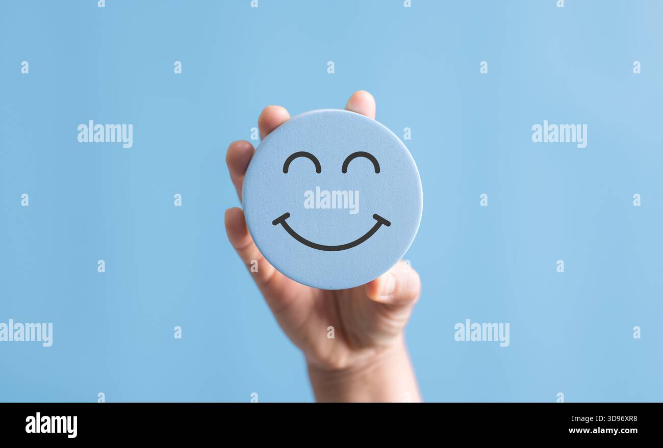 Mano che regge un sorriso felice, pensiero positivo, valutazione della salute mentale, buon feedback rating e recensione positiva del cliente, esperienza, soddisfacente Foto Stock