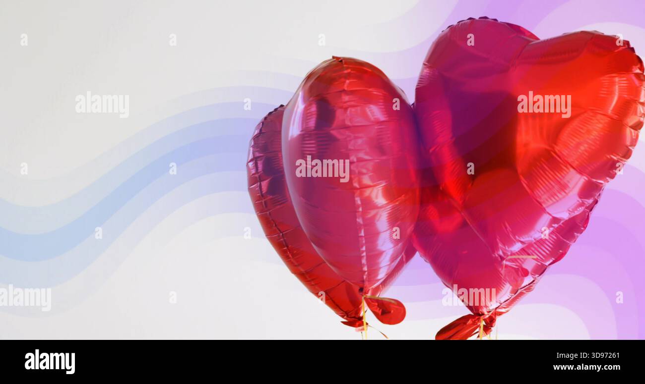 Galleggiare 2 palloncini con cuore rosso lucido che si spostano su uno sfondo ondulato pallido, mostrando cuciture e nastri Foto Stock