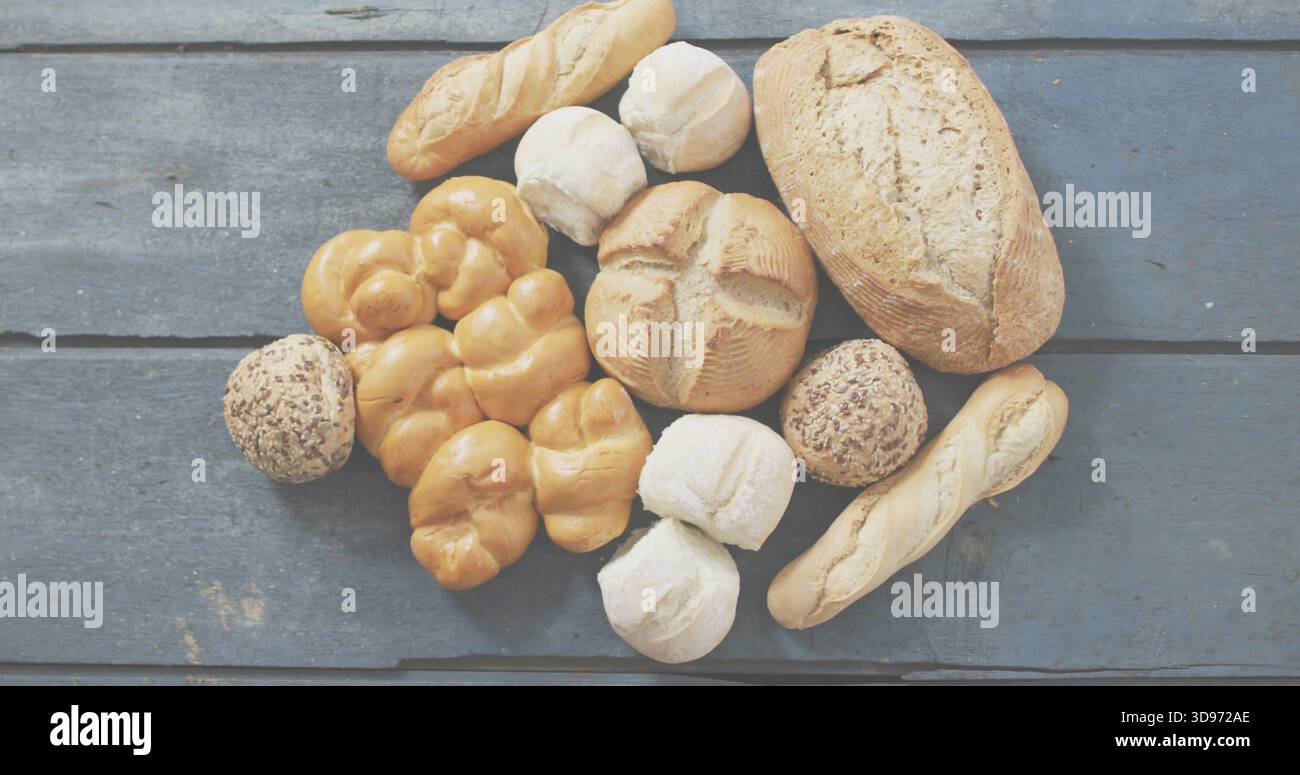 Mostra il pane che poggia su una tavola blu-grigia, con pane croccante, baguette, panini con semi Foto Stock