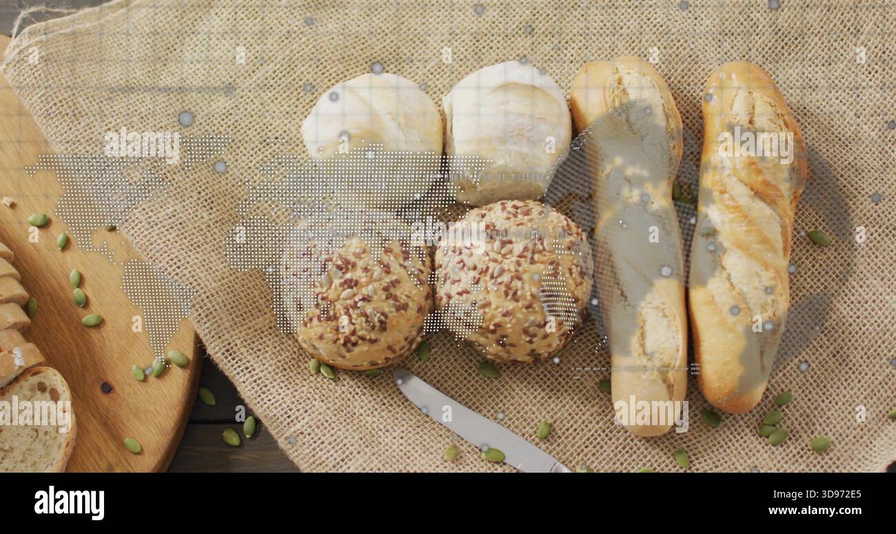 Mostra pane e panini su un rustico tavolo con semi di pepita sparsi e coltello in metallo Foto Stock