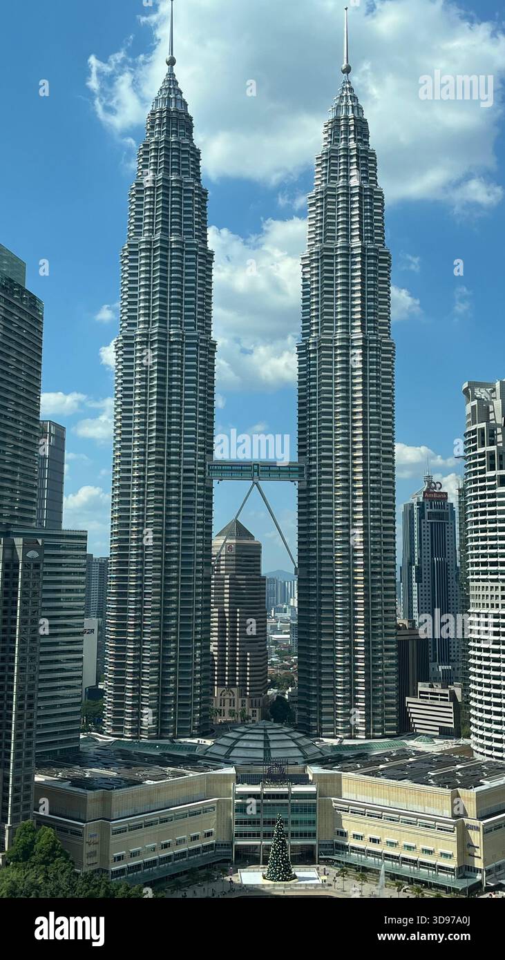 Una chiara vista diurna delle Torri Petronas a Kuala Lumpur, che mostra l'architettura moderna, il cielo blu e i grattacieli circostanti della città. - Immagine stock catturata con smartphone