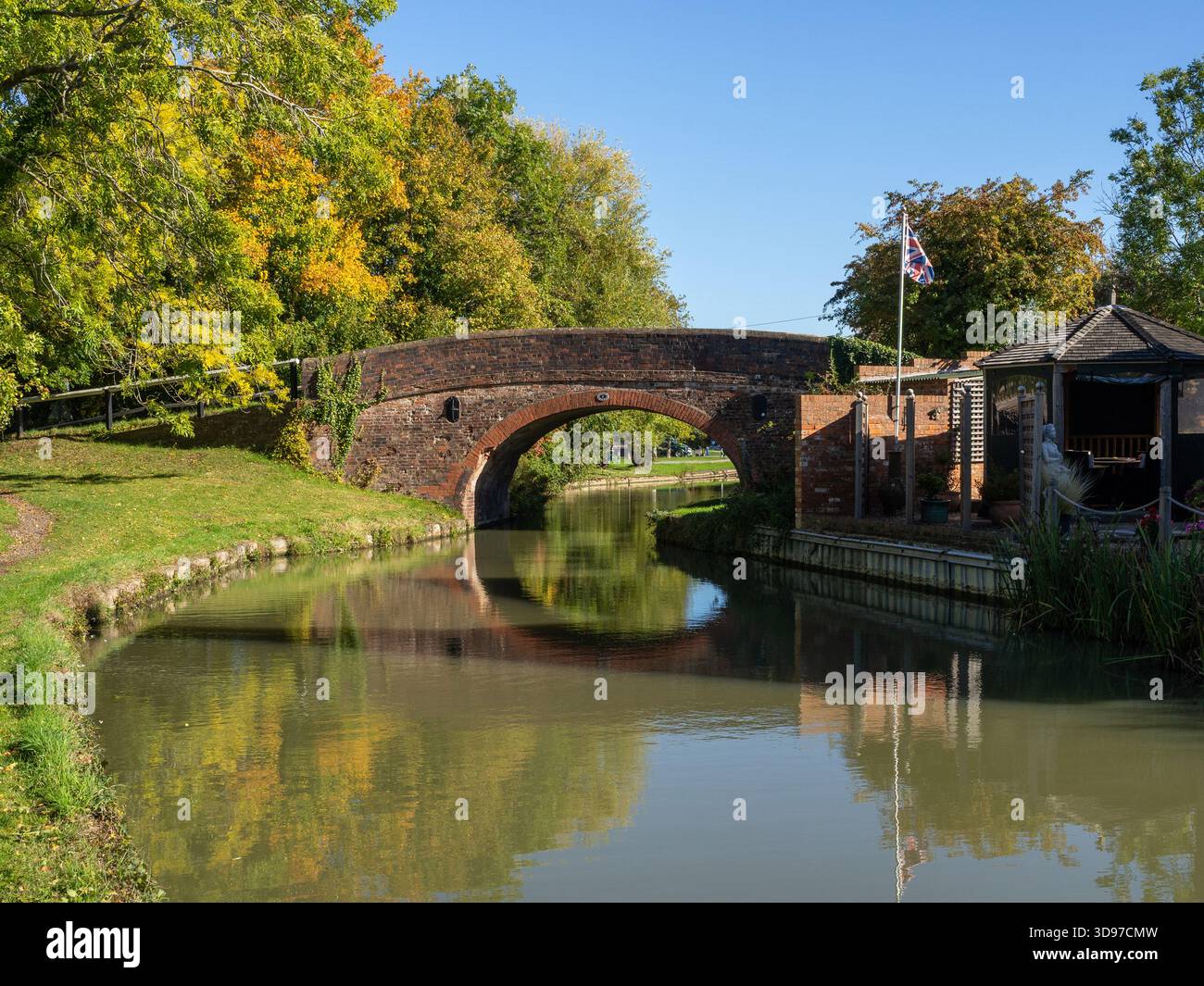 Tranquilla scena autunnale sul canale Grand Union a Blisworth Arm, Northamptonshire, Regno Unito, con il Ponte n. 2 che si riflette nelle calme acque del canale Foto Stock