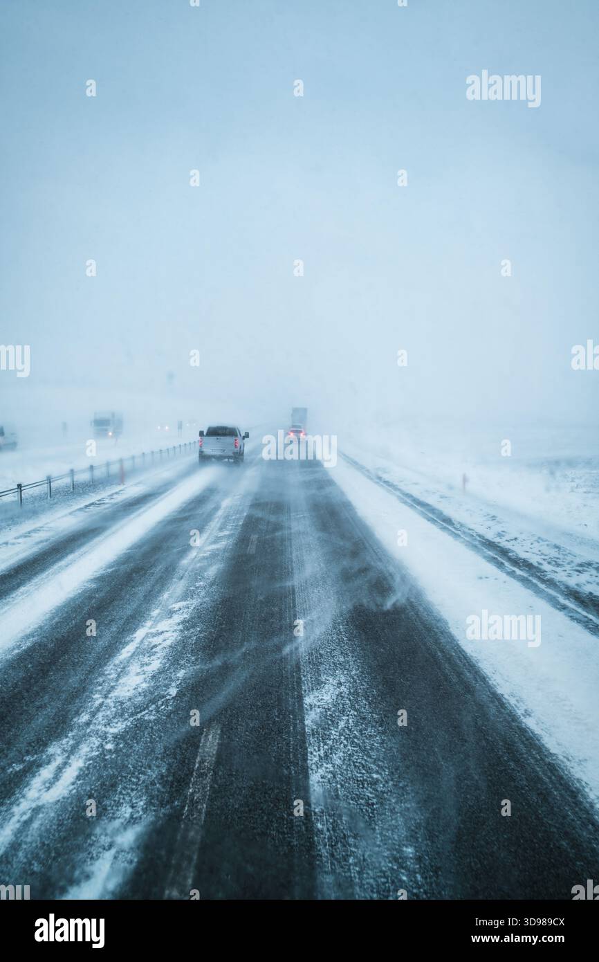 Tempesta invernale con strade coperte di neve e condizioni di guida in condizioni di neve e scarsa visibilità in Islanda Foto Stock
