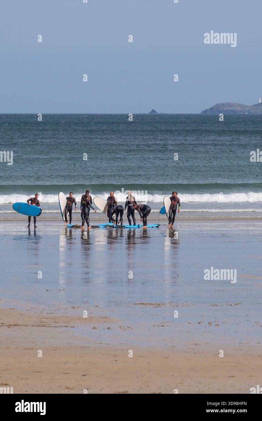 Un gruppo di vacanzieri in una lezione di surf alla spiaggia di Towan a Newquay, in Cornovaglia, in Inghilterra, nel Regno Unito. Foto Stock