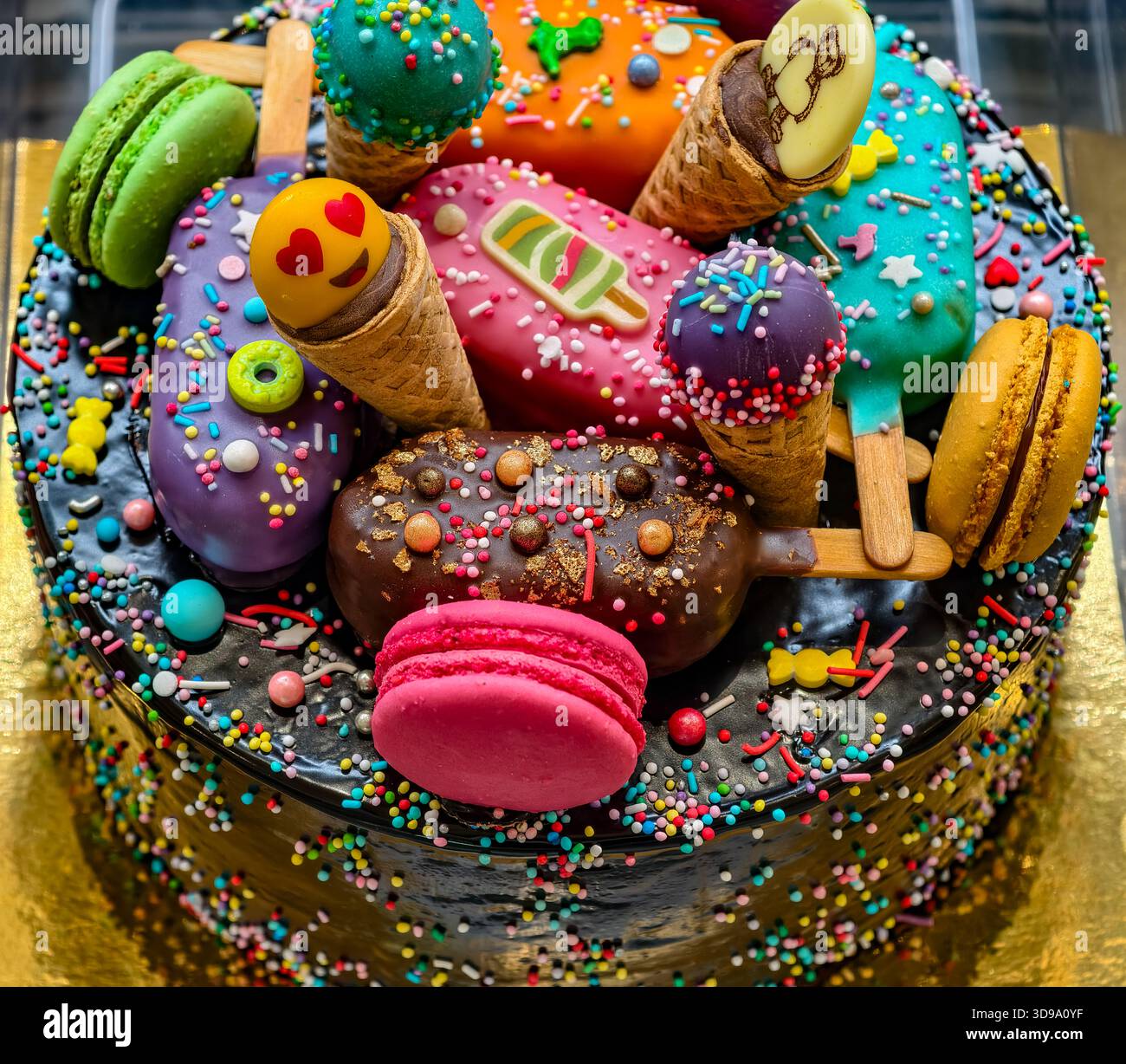 Torta di compleanno con glassa di cioccolato e colorate caramelle per feste o celebrazioni per bambini. Sfondo dolci Foto Stock