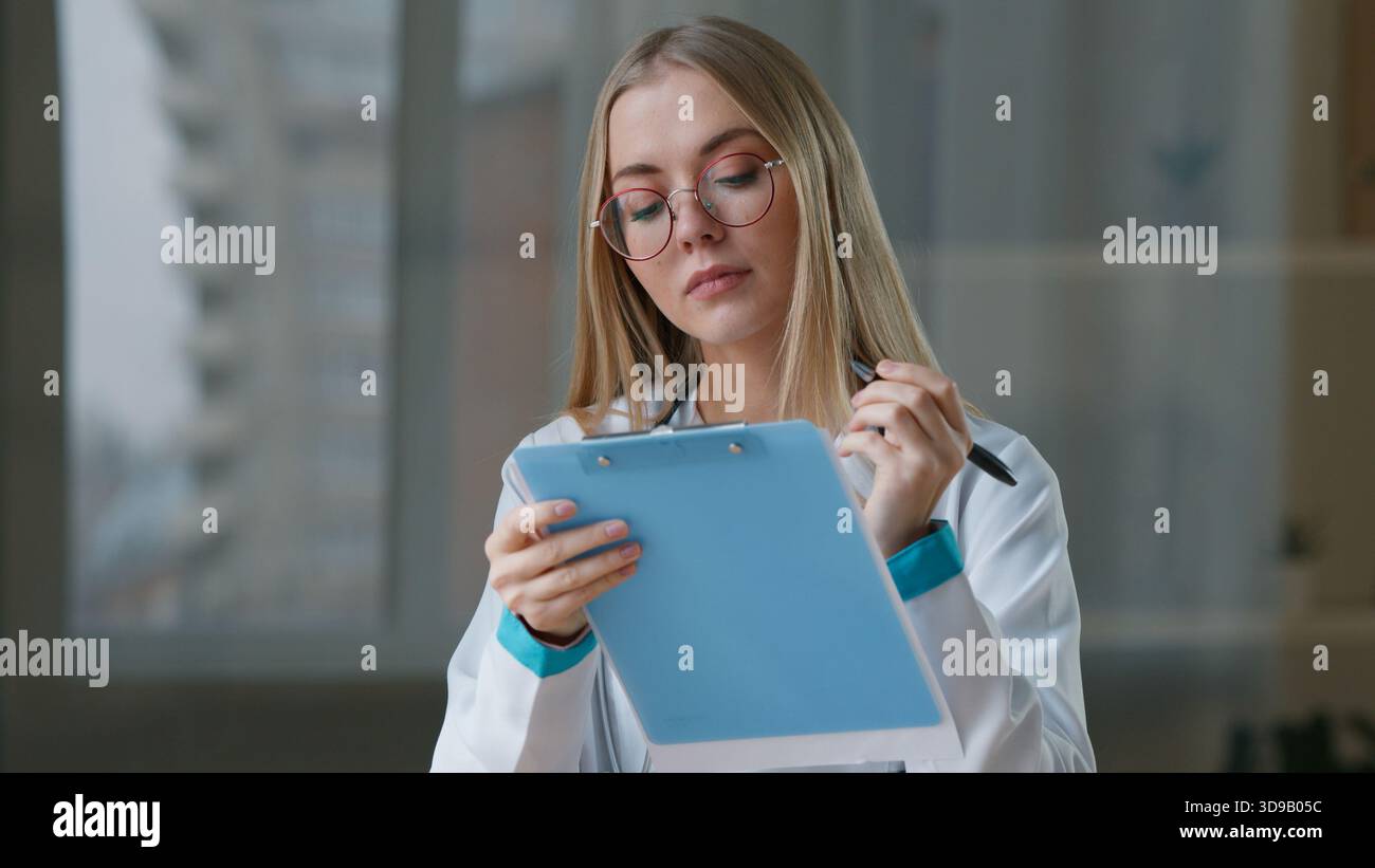 Donna caucasica medico infermiera scrittura in carta medica prescrizione farmaco in clinica donna medico medico lavoratore ragazza in ospedale scrivere Foto Stock