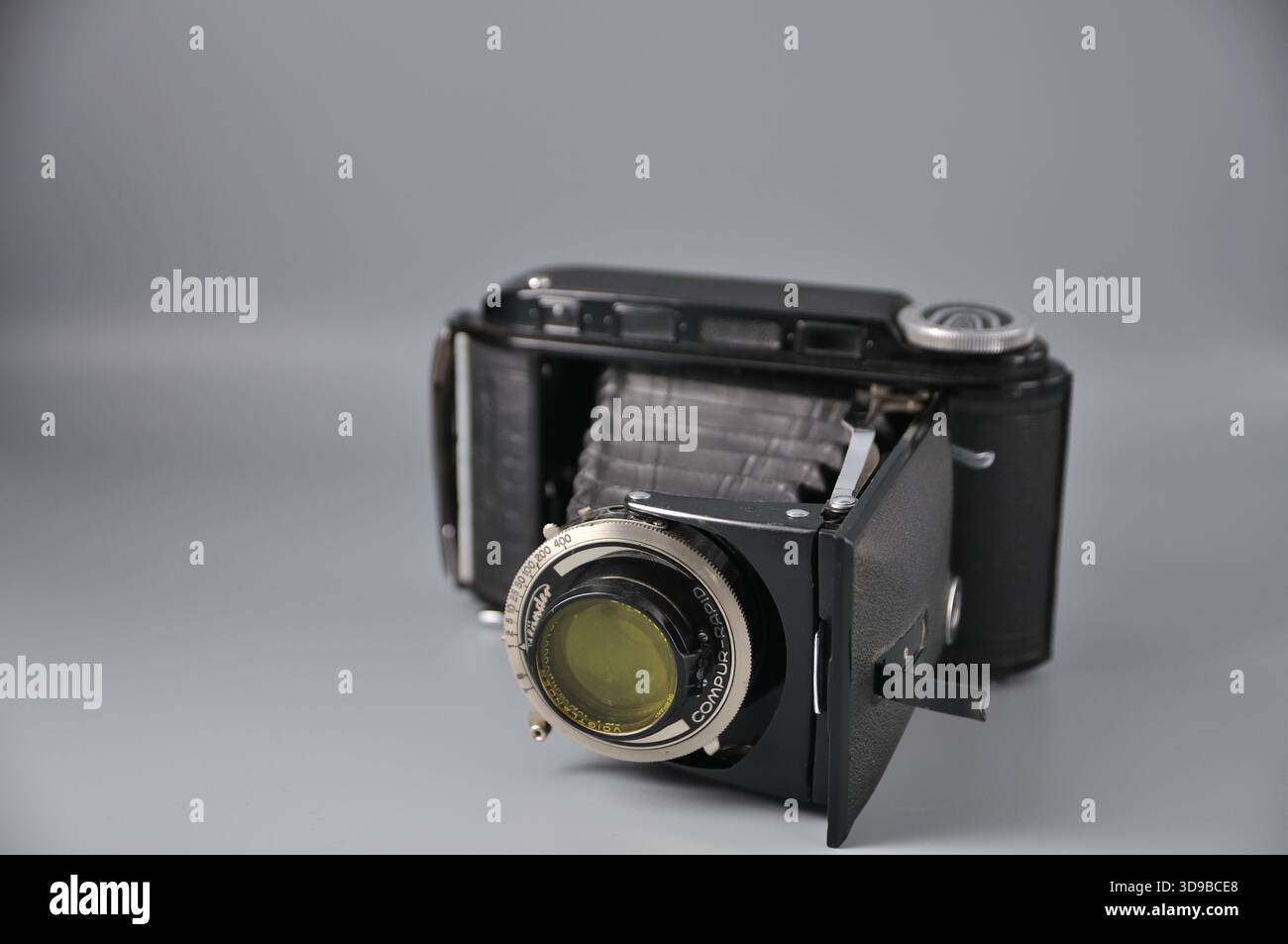 Vecchia telecamera a soffietto pieghevole con comandi manuali, compatta quando ripiegata. Un capo da collezione perfetto per gli amanti della fotografia classica. Foto Stock