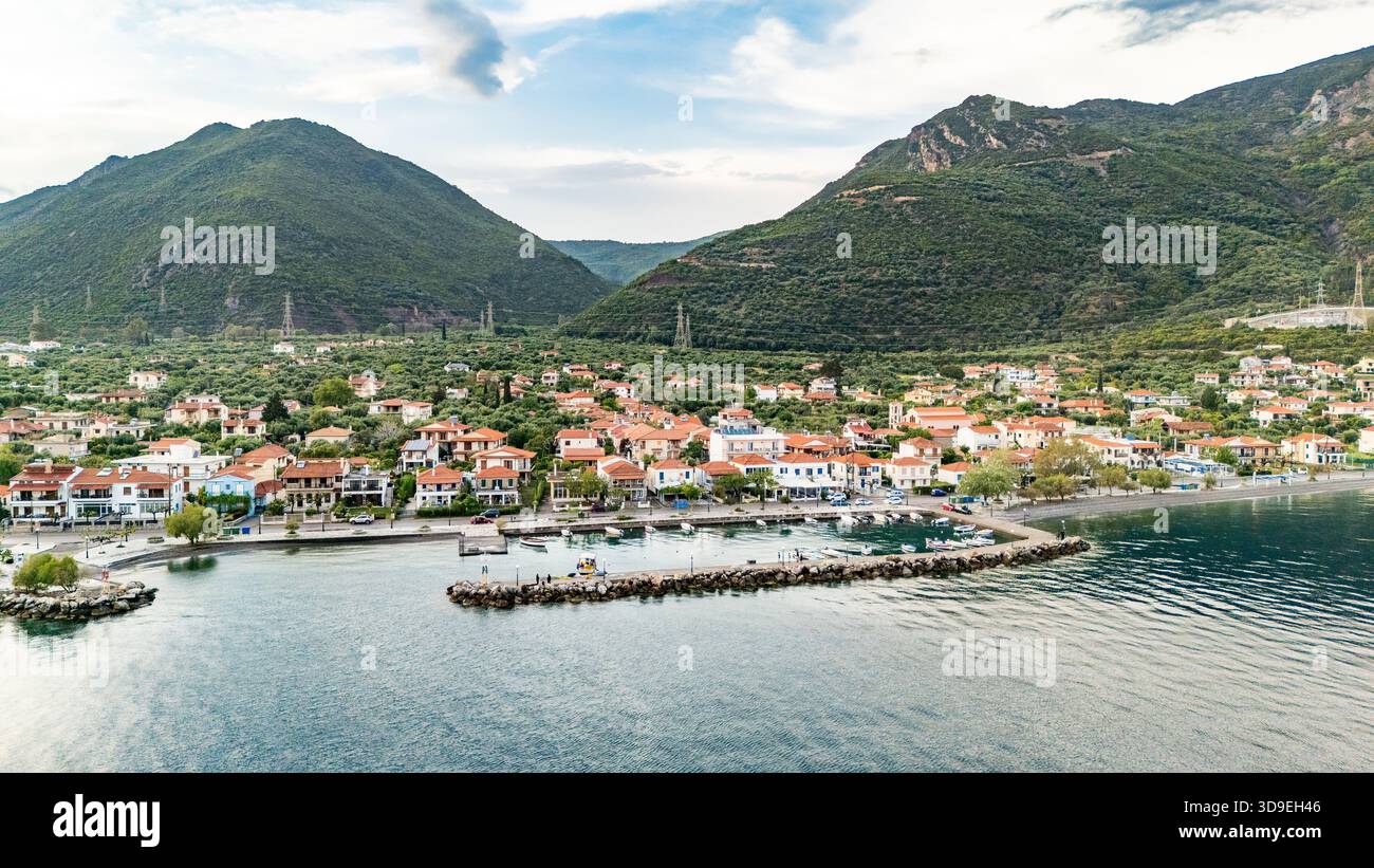 Vista aerea con droni di Marathias, un villaggio costiero della Grecia centrale, che mostra la costa e il porto del Golfo di Corinto. Foto Stock