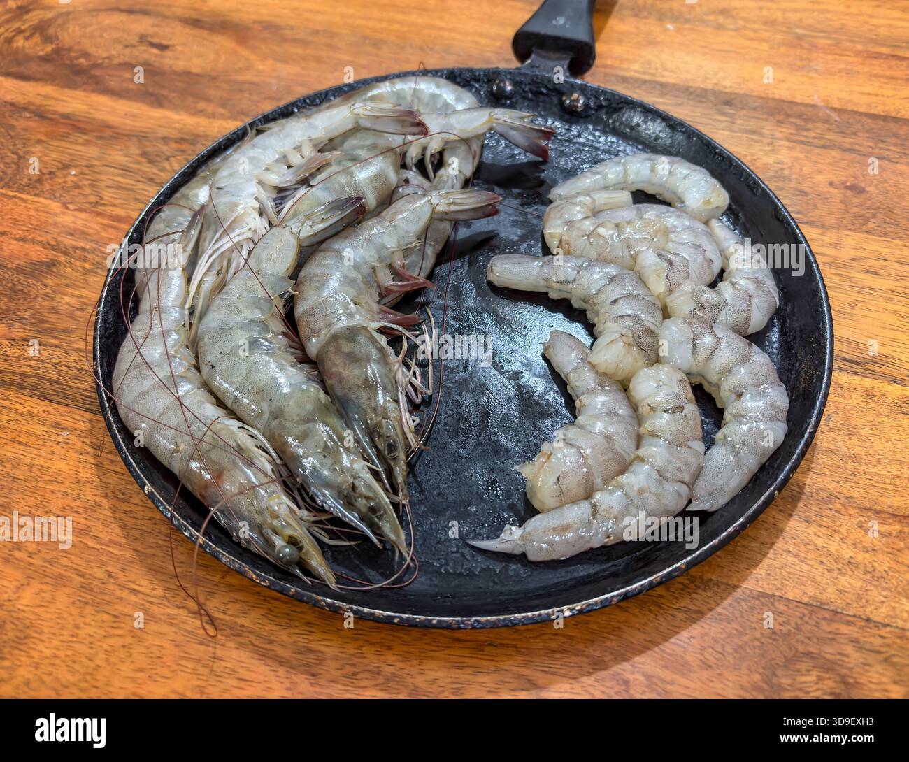 gamberi crudi preparati per la cottura a base di pesce su un tavolo di legno Foto Stock