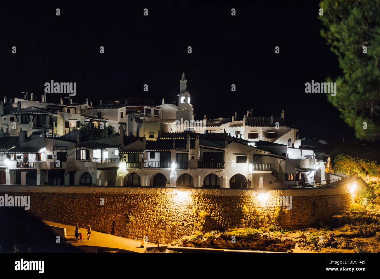 Vista notturna delle case illuminate a Binibeca Vell, Minorca Foto Stock