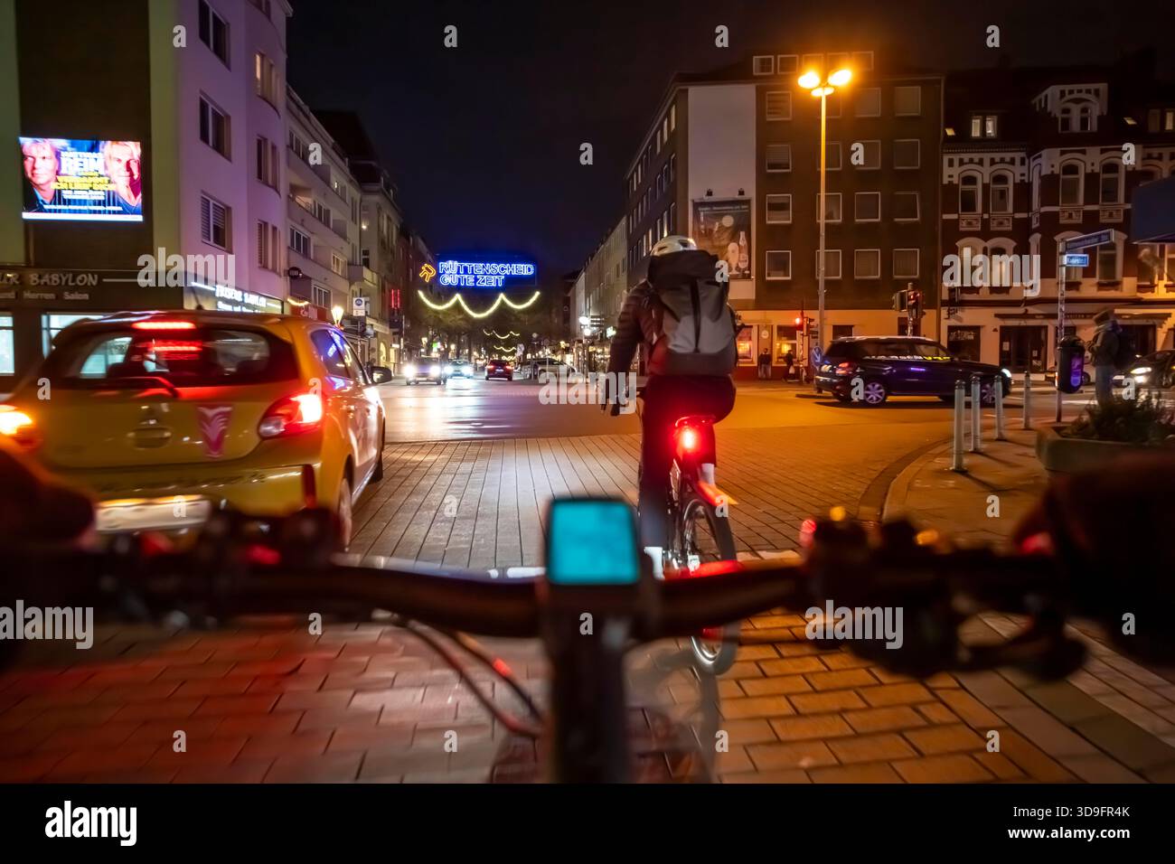 In bicicletta in città, al buio, alla sera, in città, in pista ciclabile, il traffico a due ruote ha la priorità, zona 30 km/h, prospettiva del ciclista, Foto Stock