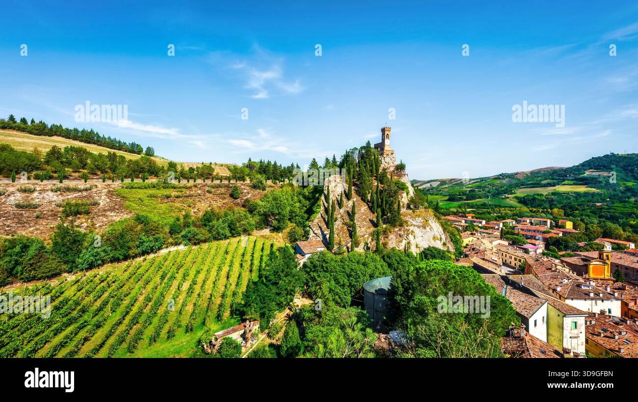 Vista estiva del borgo medievale di Brisighella, Emilia-Romagna, Italia. L'iconica Torre dell'Orologio si erge in cima a un torreggiante sperone roccioso, affacciato sul A. Foto Stock