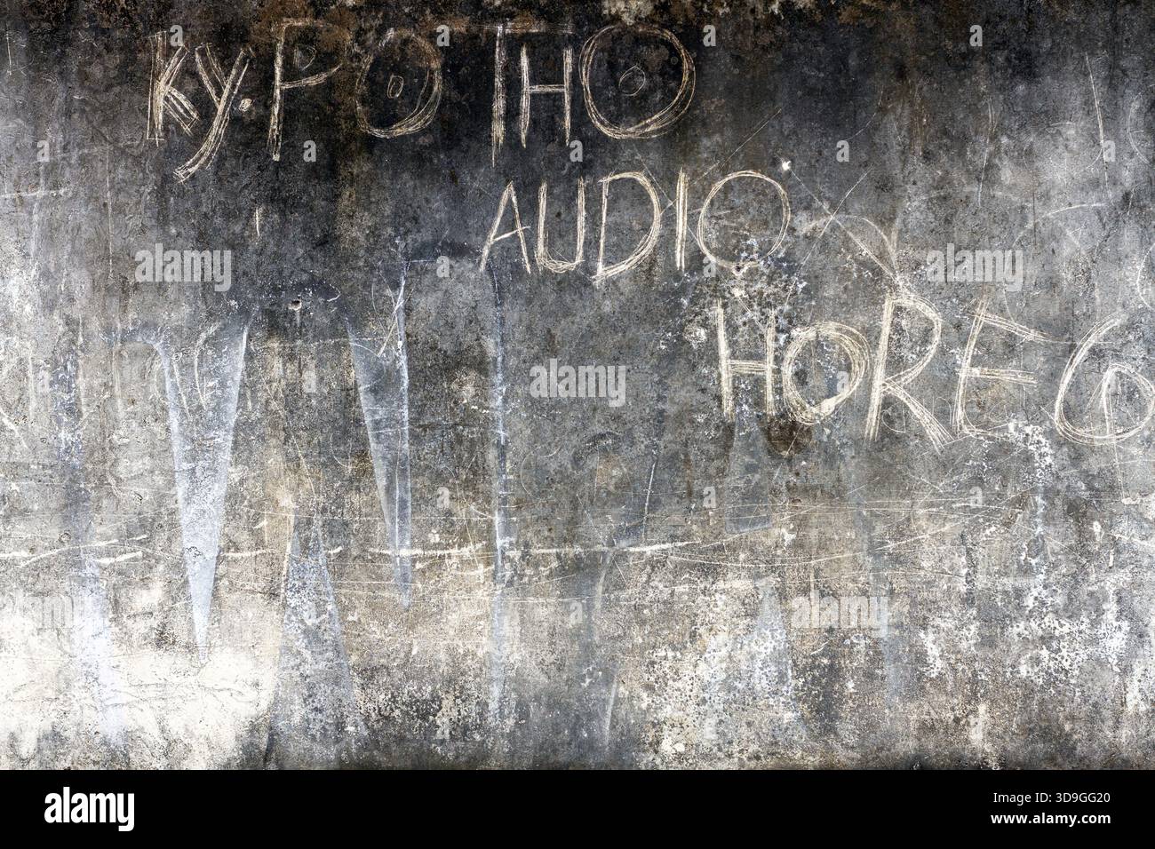 Sfondo grunge orizzontale, scuro e soffice di una parete in cemento con gesso sbiadito raschiato a mano o graffiti. La superficie è molto wa Foto Stock