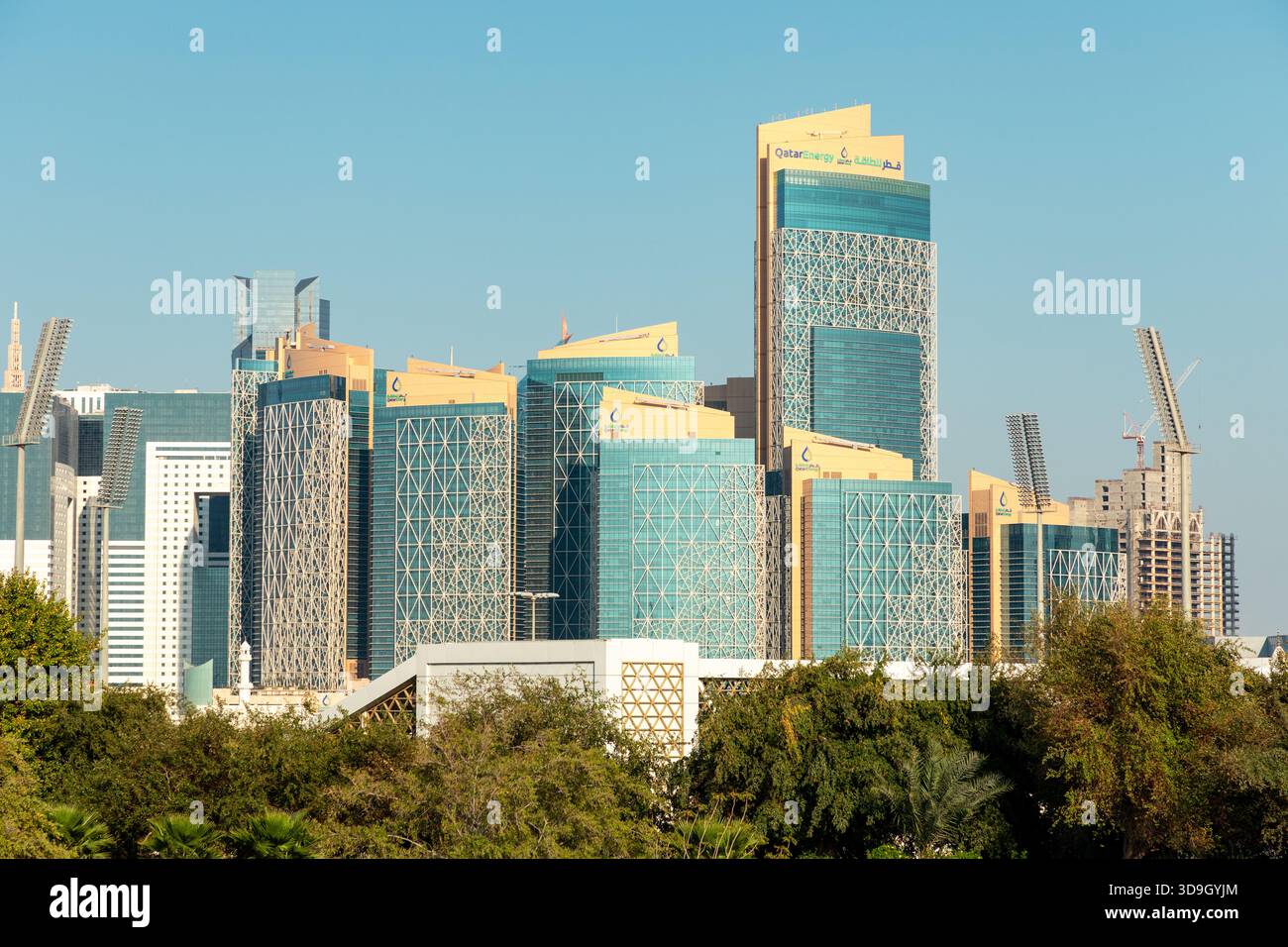 Sede centrale di QatarEnergy, Doha, Qatar: 19 marzo 2025. Un impressionante gruppo di grattacieli di vetro blu marchiati con Qatar Energy sorge su di un verde Foto Stock
