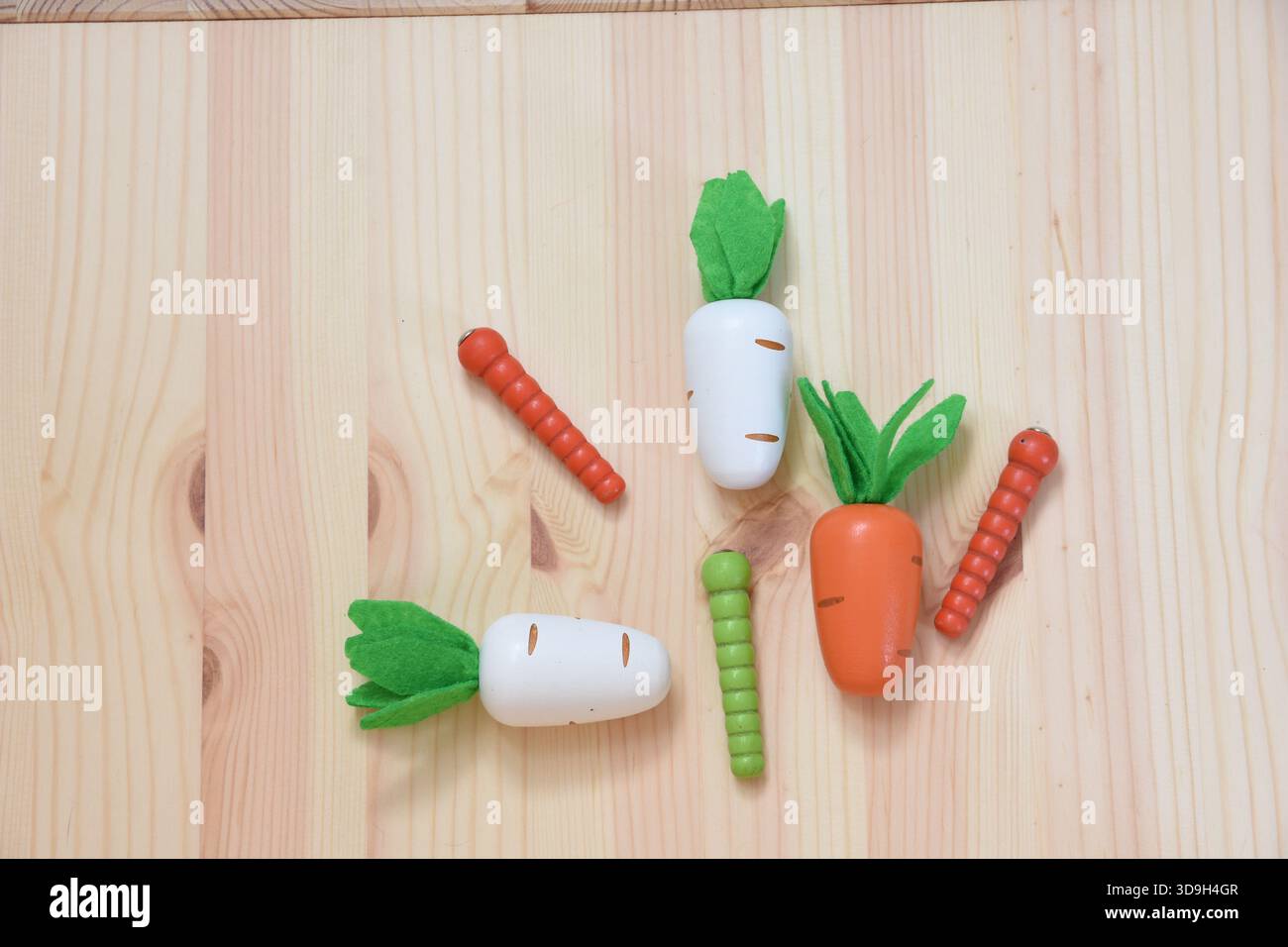 giocattoli colorati in legno raffiguranti carote e vermi Foto Stock