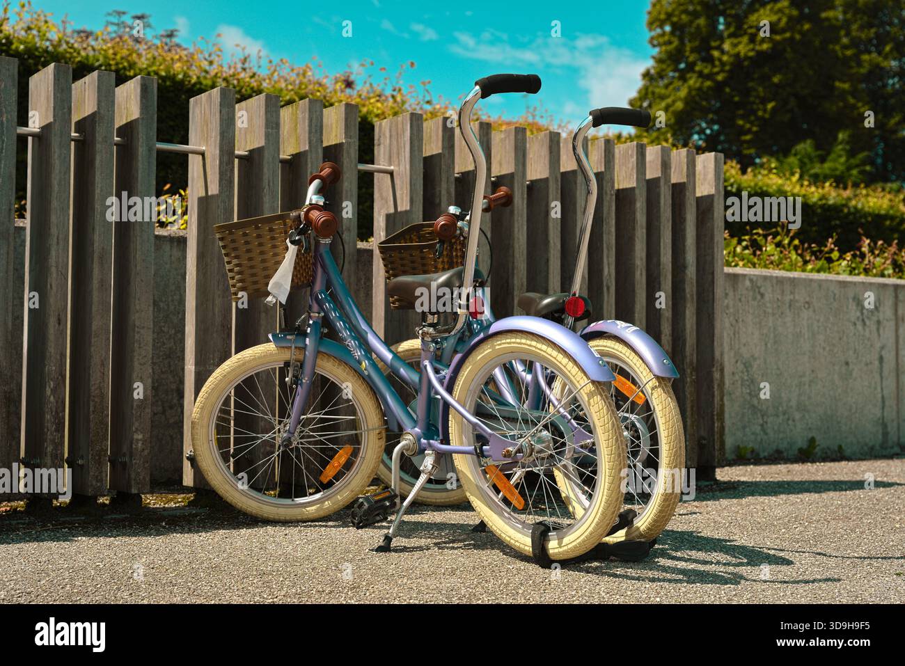 Due biciclette per bambini parcheggiate in una giornata di sole sotto un cielo azzurro e limpido, ma con nuvole discontinue, vicino a Roskilde Marina Foto Stock