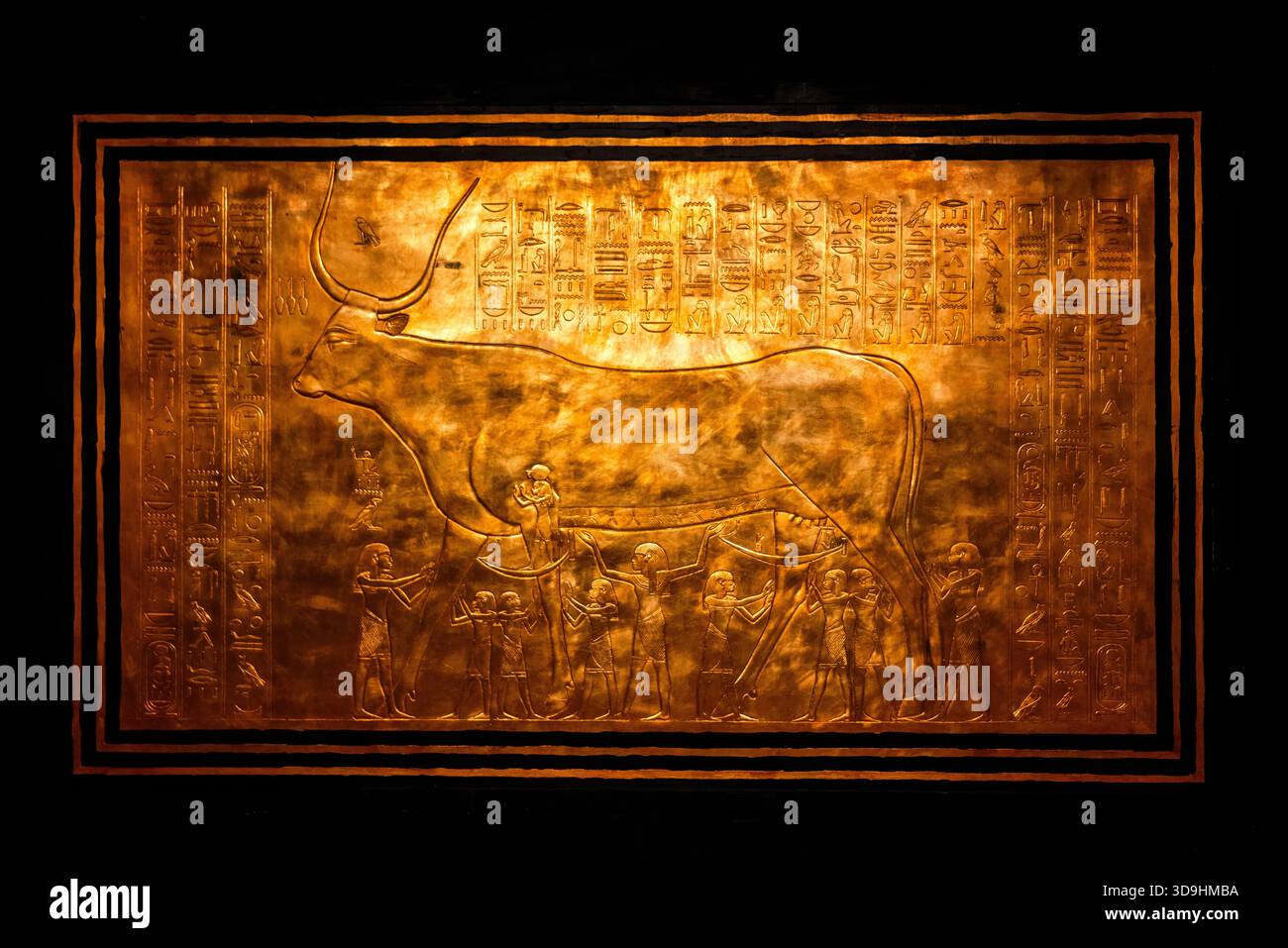Primo piano dettagliato di un pannello di santuario dorato dalla camera di sepoltura di Tutankhamon che mostra il toro sacro e i geroglifici, evidenziando l'antica ar egizia Foto Stock