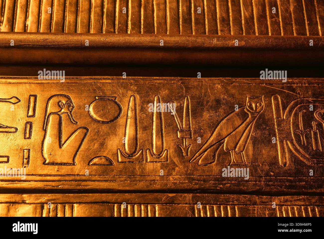 Primo piano dettagliato di geroglifici egiziani dorati incisi su un pannello del santuario dalla camera di sepoltura di Tutankhamon, che mostra arte antica, simboli e artigianato Foto Stock