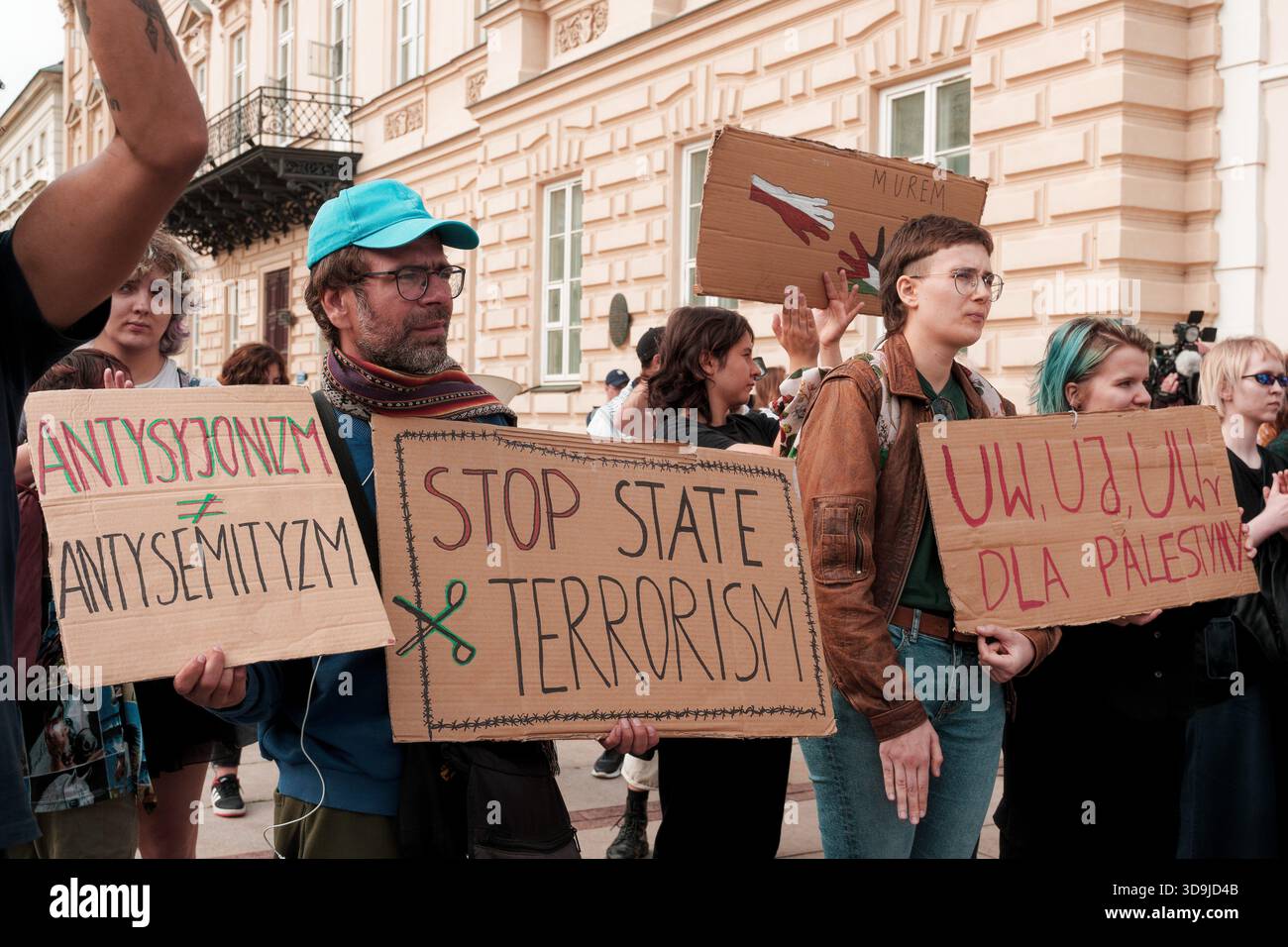 I manifestanti hanno segni di cartone che denunciano la violenza di Stato e che esprimono solidarietà alla Palestina. Foto Stock