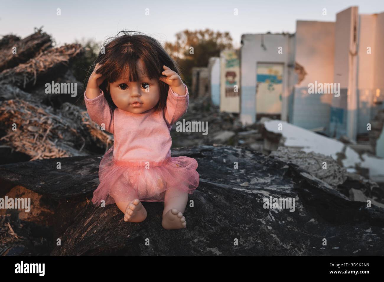 la bambola solitaria con uno sguardo triste si trova abbandonata in un asilo distrutto, una profonda tragedia di guerra e il suo impatto devastante sull'infanzia. concetto di horr Foto Stock