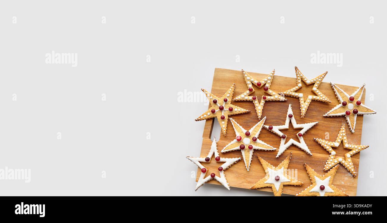 Regali di Natale, cibo funky, regali fatti a mano, amore. Tagliere isolato in legno con biscotti a forma di stella, smaltato e decorato Foto Stock