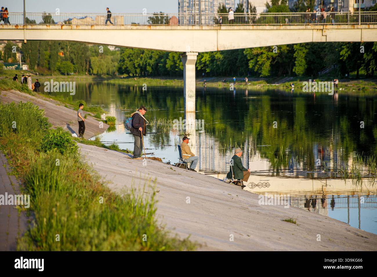 Kiev, Ucraina, agosto 2021. Pescatori sul canale di Rusanivka. Proprio di fronte a questo tranquillo luogo, un edificio residenziale è stato colpito da una mancanza russa Foto Stock