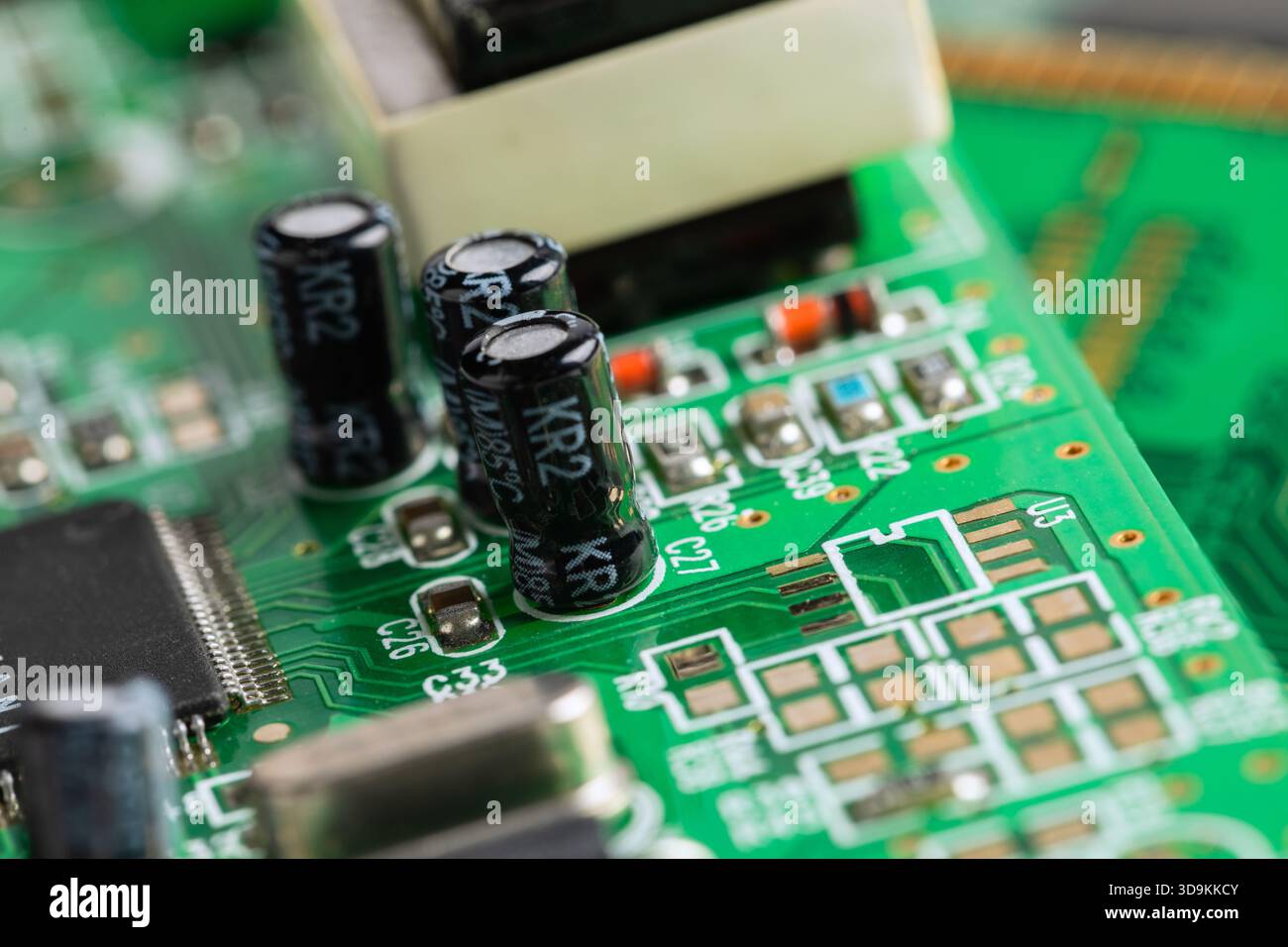 Circuito stampato verde dettagliato con condensatori, resistori e un microchip. Connessioni complesse alimentano l'elettronica moderna. Foto Stock